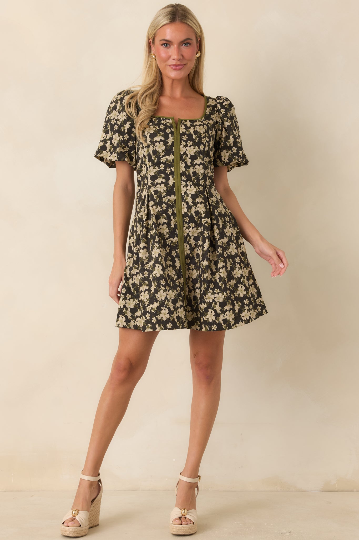 Black floral fit-and-flare mini dress featuring a square neckline with olive green trim, puff sleeves, and a softly pleated skirt.