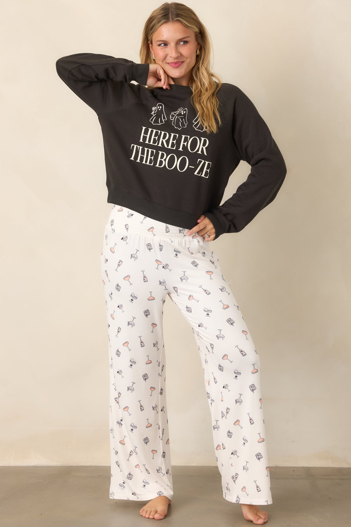 Relaxed washed black sweatshirt showcasing three ghost graphics carrying cocktails above oversized “Here for the Boo-ze” lettering.