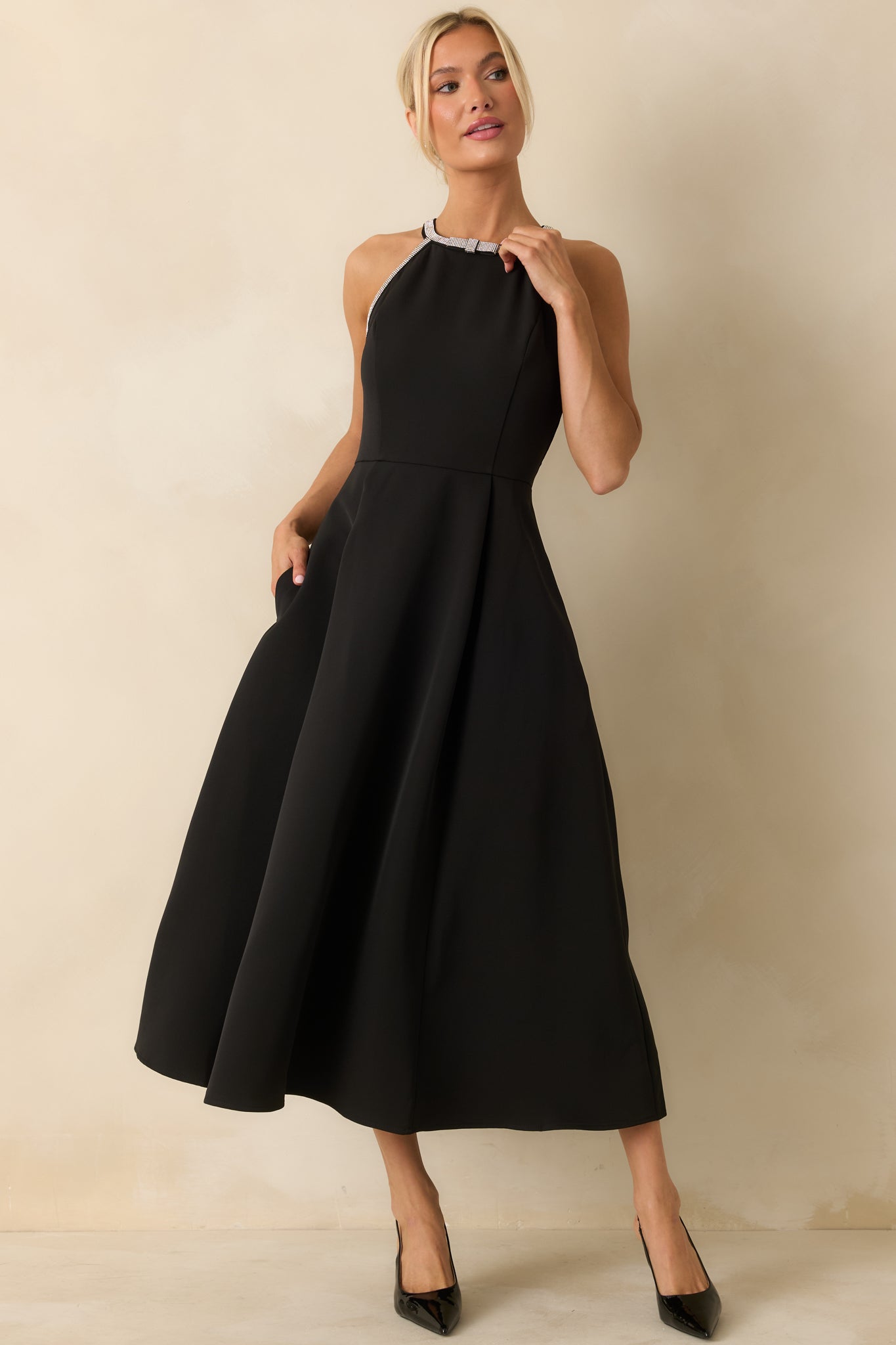 Black halter midi dress with a rhinestone-trim neckline, fitted bodice, and pleated A-line skirt.