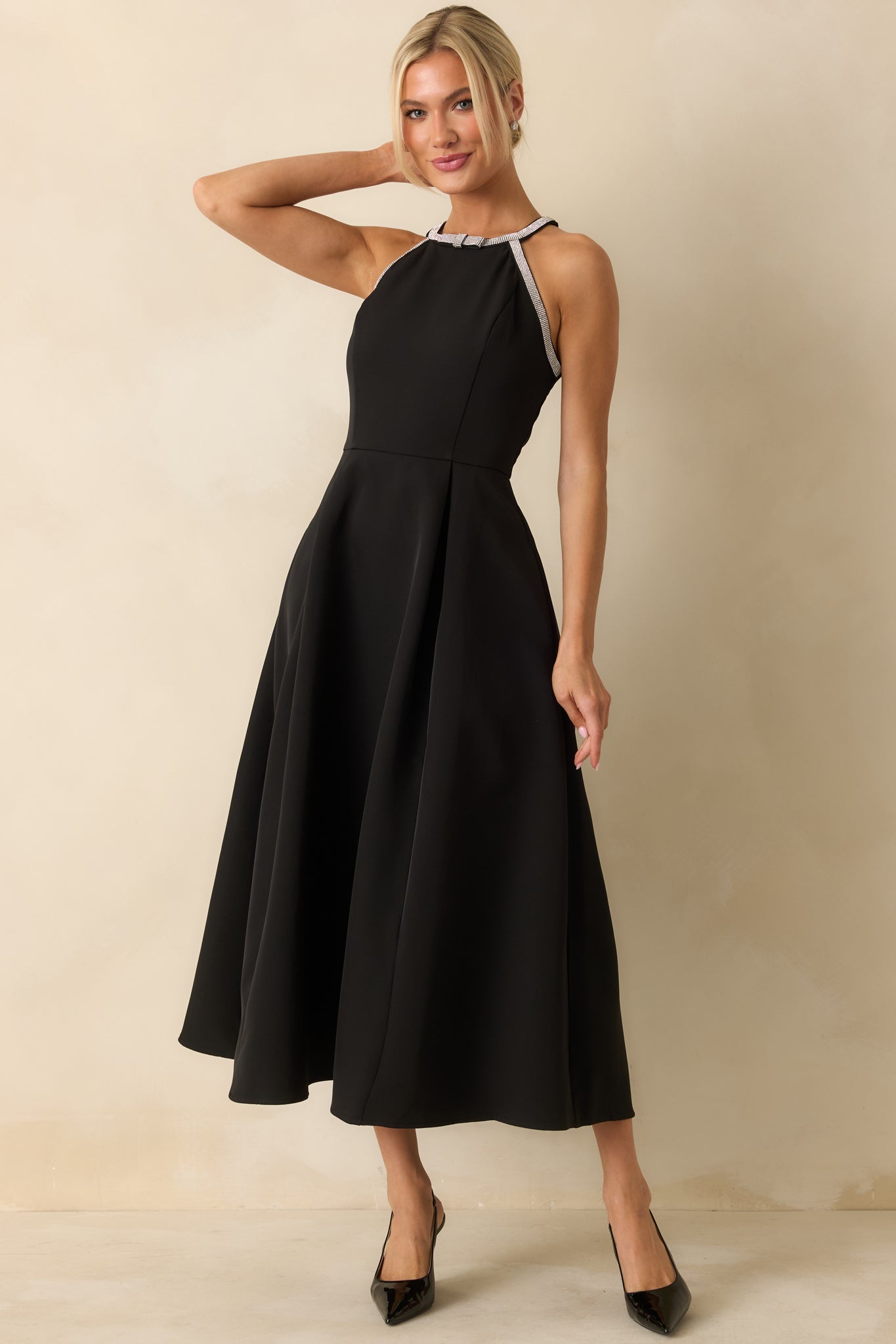 Classic black halter midi dress with a rhinestone-trim neckline, smooth fitted bodice, and gently flared pleated skirt.