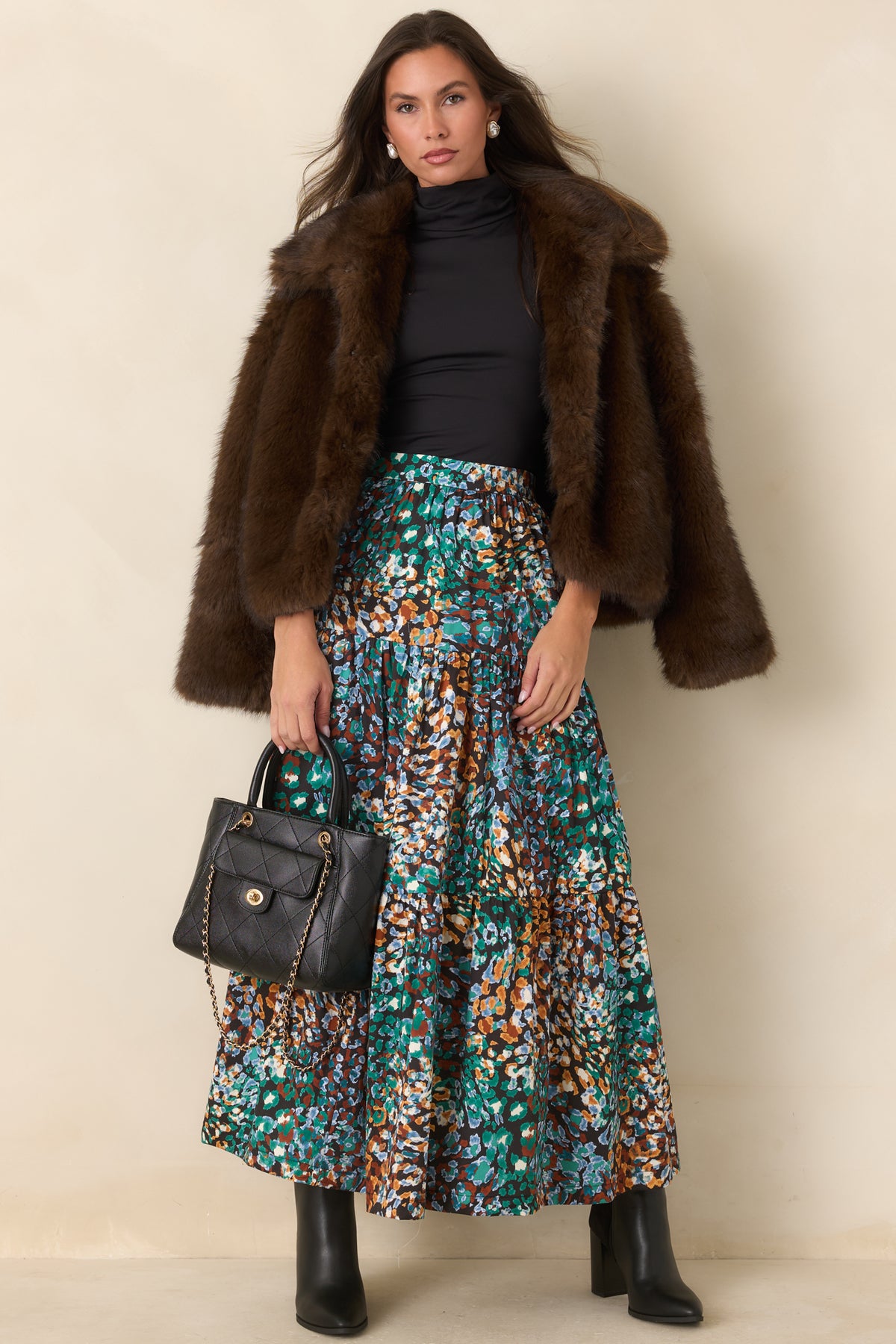 Black skirt with a fitted high-rise waistband and flowing tiered silhouette.