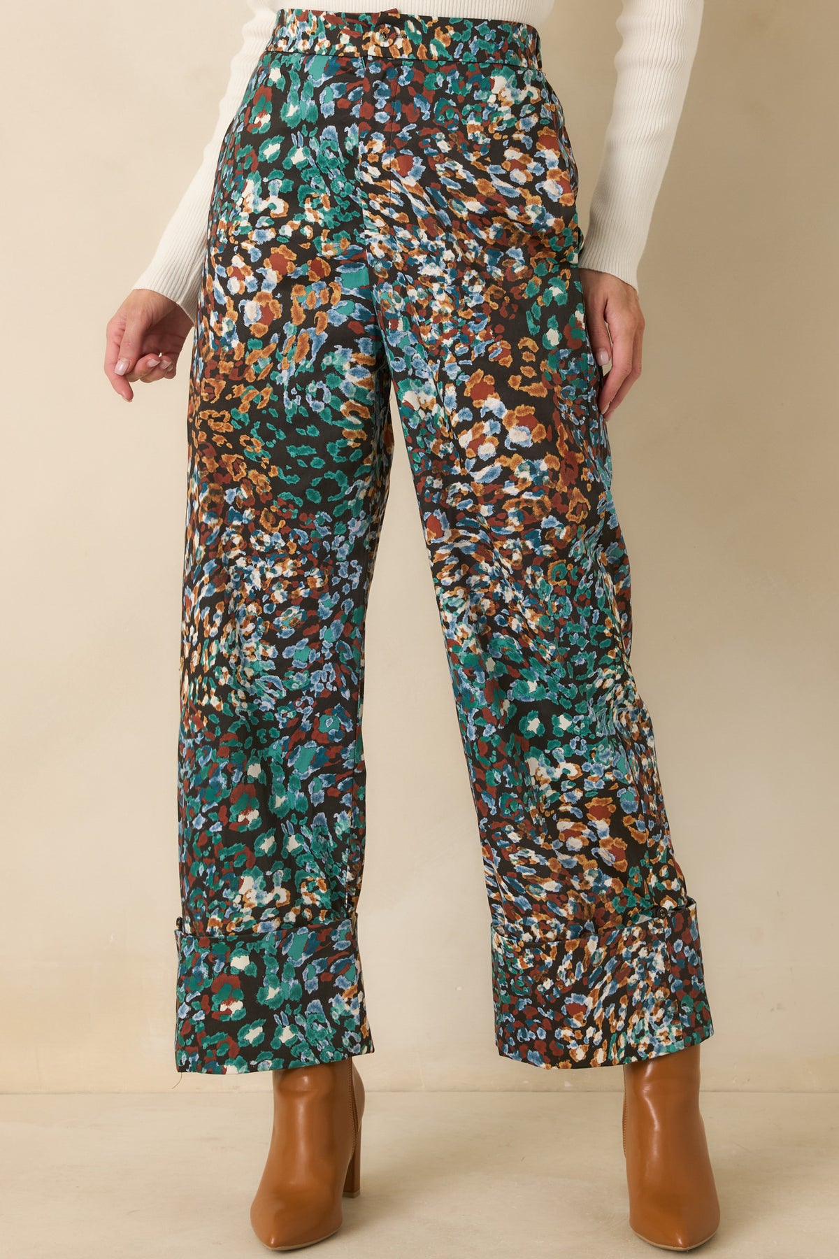 Black high-rise pants highlighting the zipper fly and fabric-covered button closure.