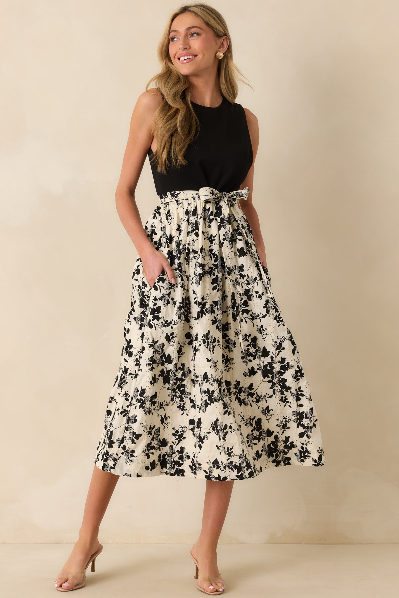 Black and ivory dress with a fitted bodice and flared floral skirt.