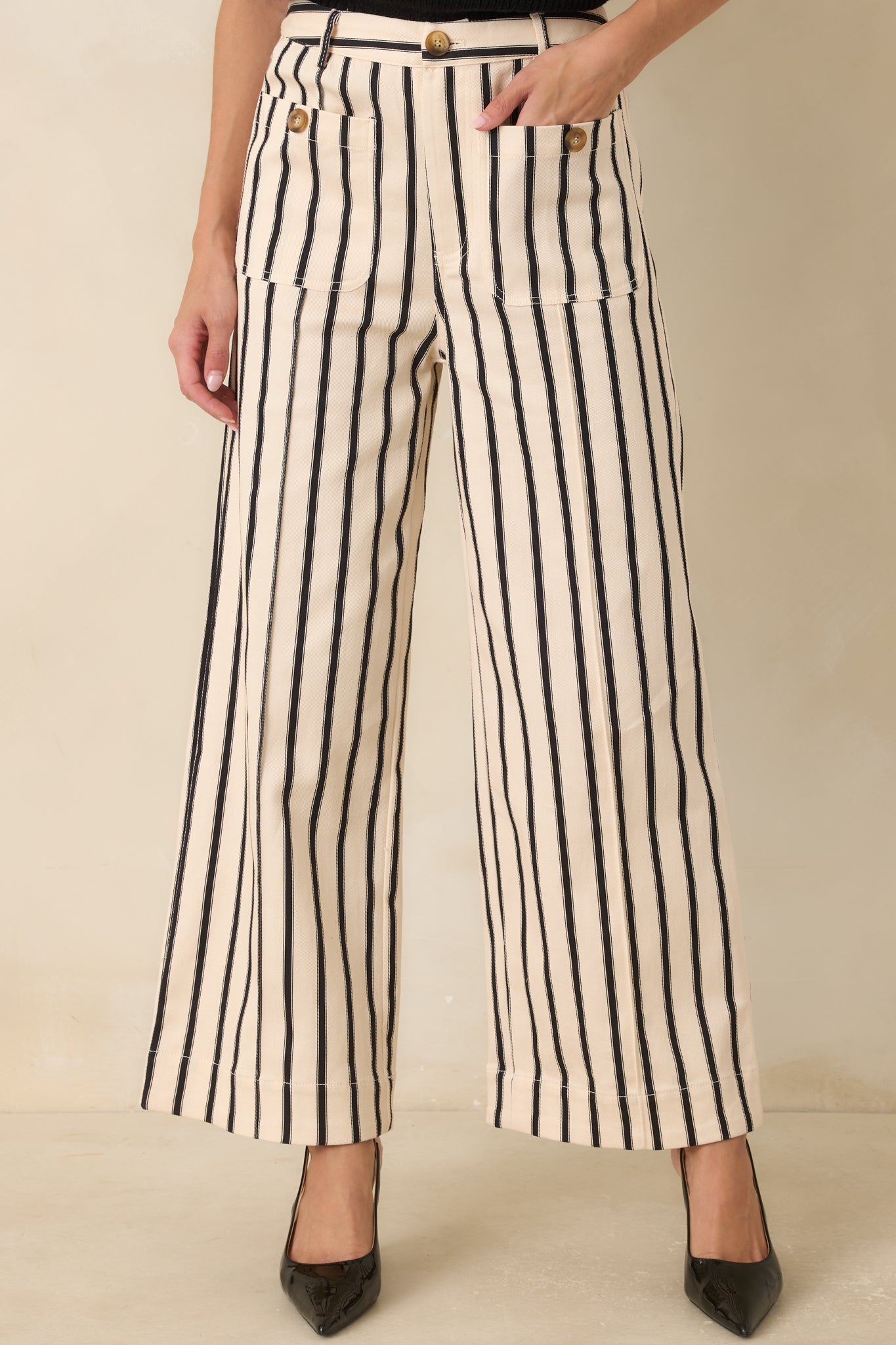 Partial view of the black and ivory striped fabric highlighting the relaxed wide-leg construction and smooth finish.