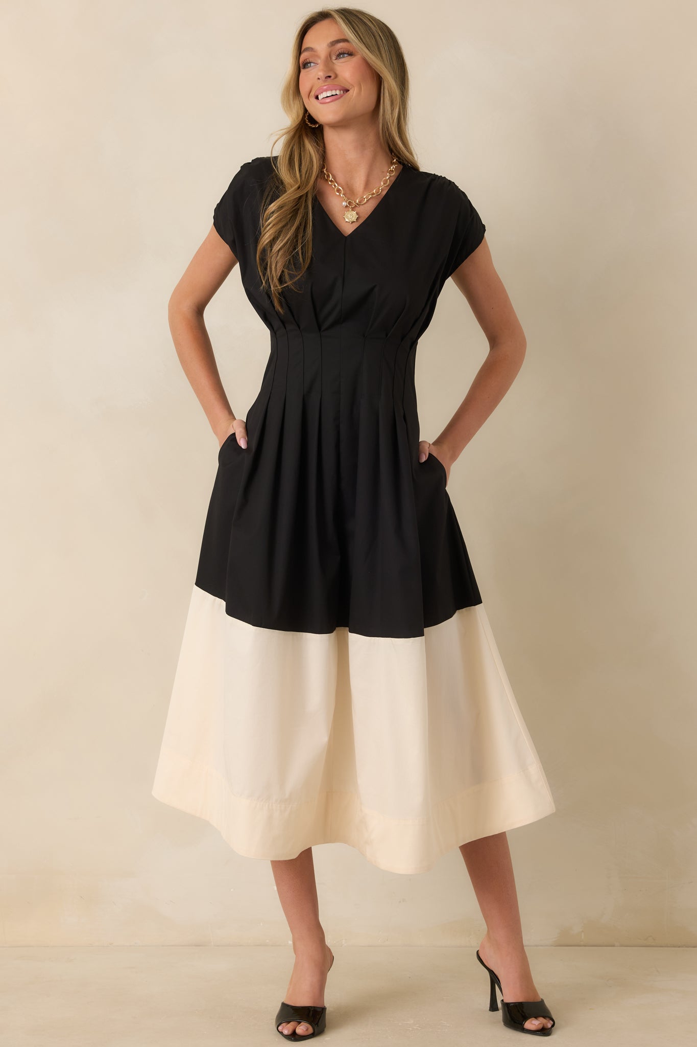 Black and ivory midi dress showcasing a classic V-neckline, side pockets, and a fully lined design for lasting comfort.