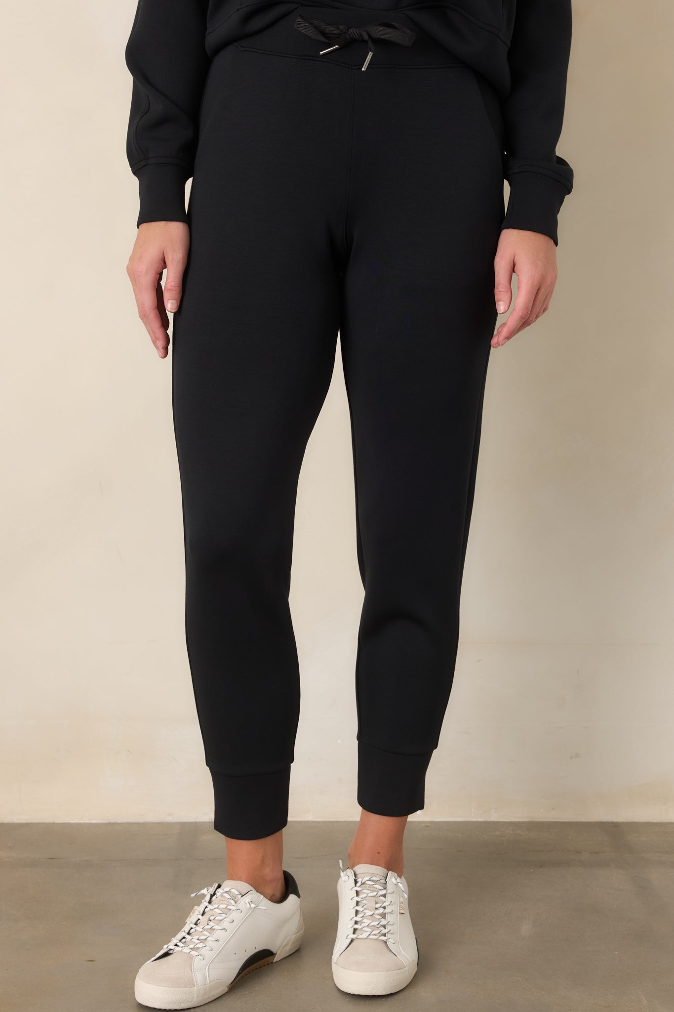 Close view of the black joggers highlighting the relaxed upper fit and functional side pocket.