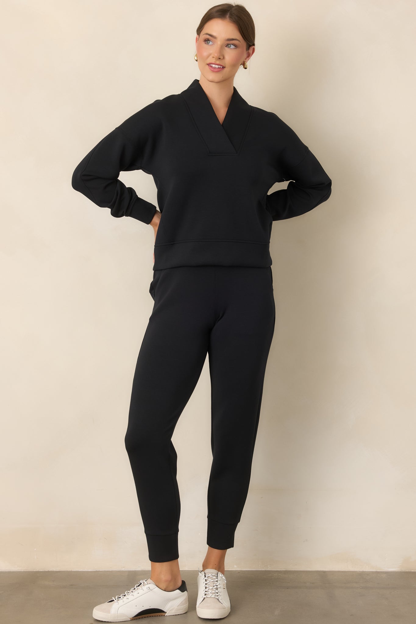 Lightweight black joggers featuring a smooth finish, relaxed legs, functional side pockets, and polished banded cuffs.