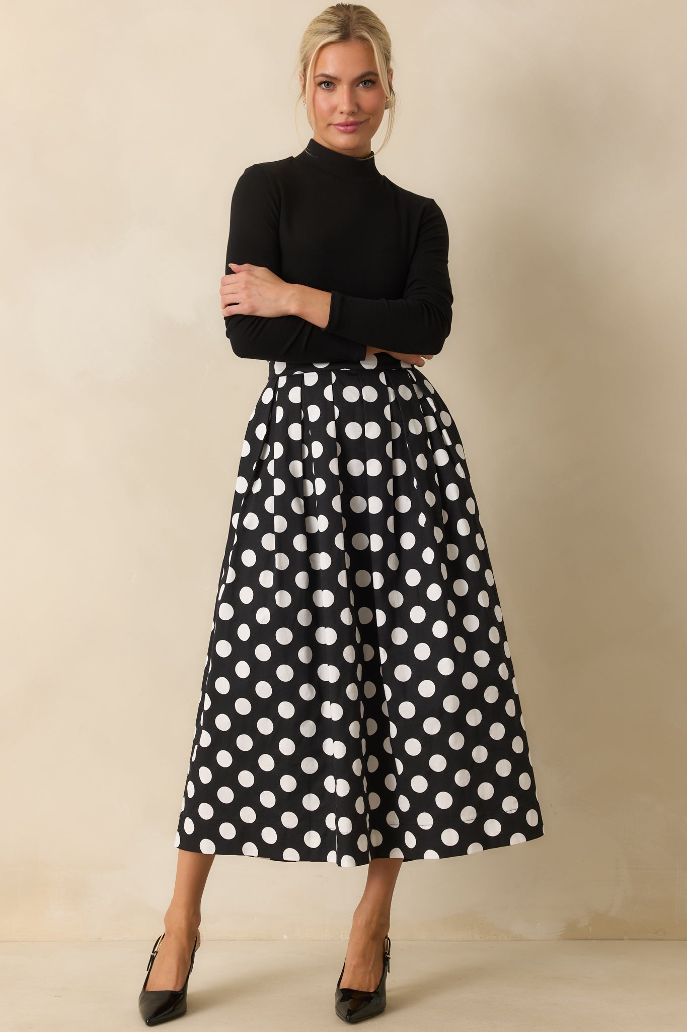 Black long sleeve top with a sleek turtleneck and slightly fitted silhouette.