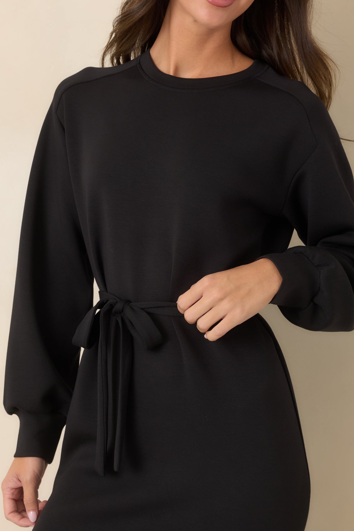 Close-up of the matching black waist tie and clean fabric detailing.