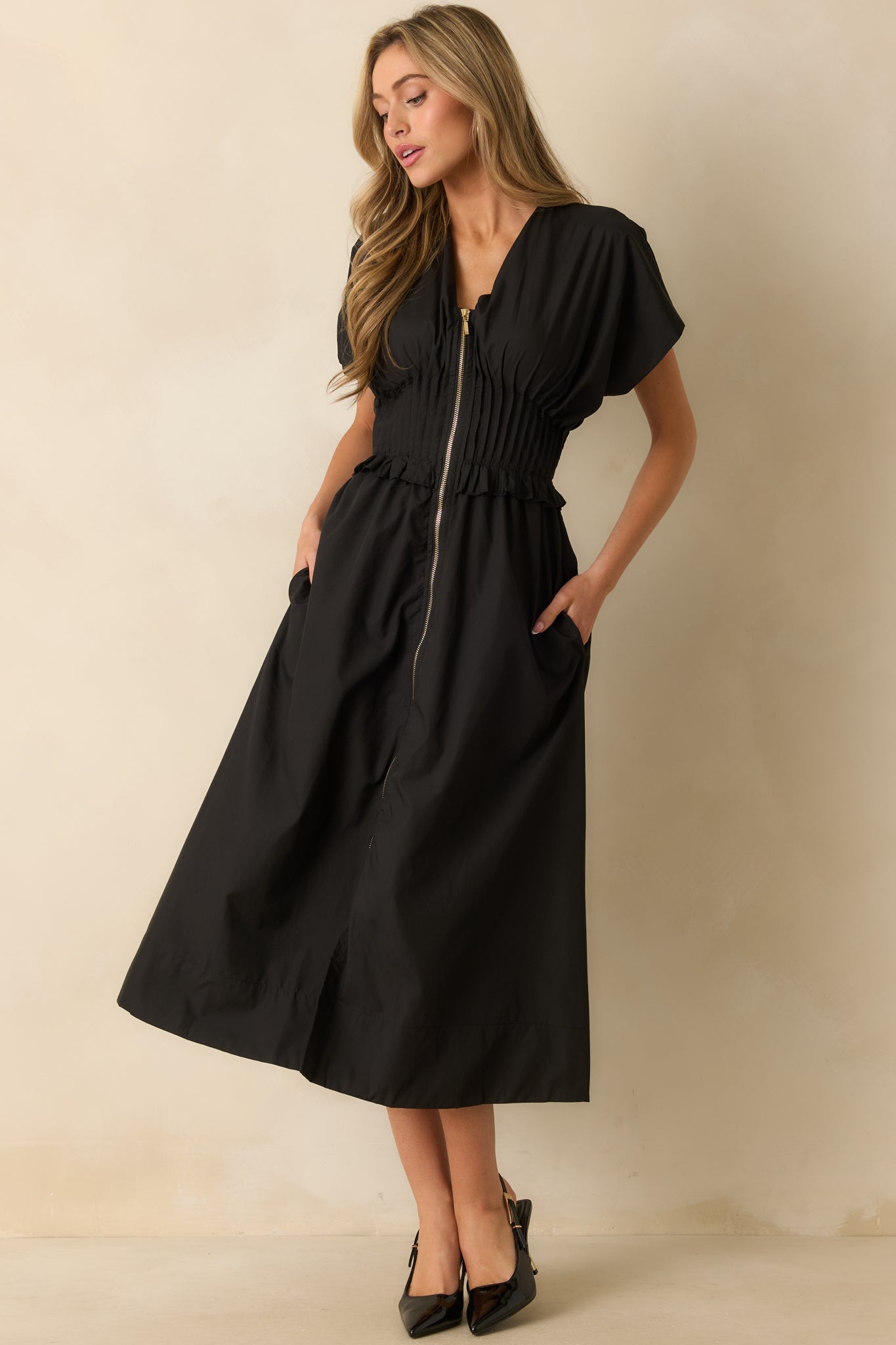 Black maxi dress highlighting the wide smocked waistband with ruffled trim and side pockets for a comfortable, flattering look.