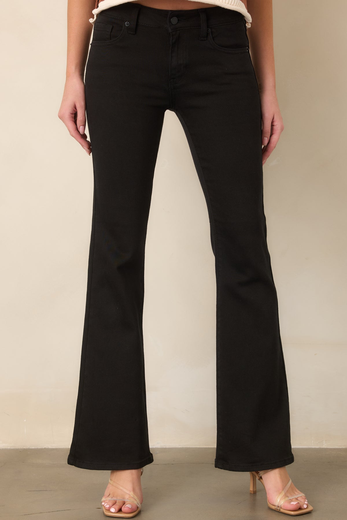 Mid-rise black denim jeans highlighting the comfortable stretch and close-fitting shape through the hips and thighs.