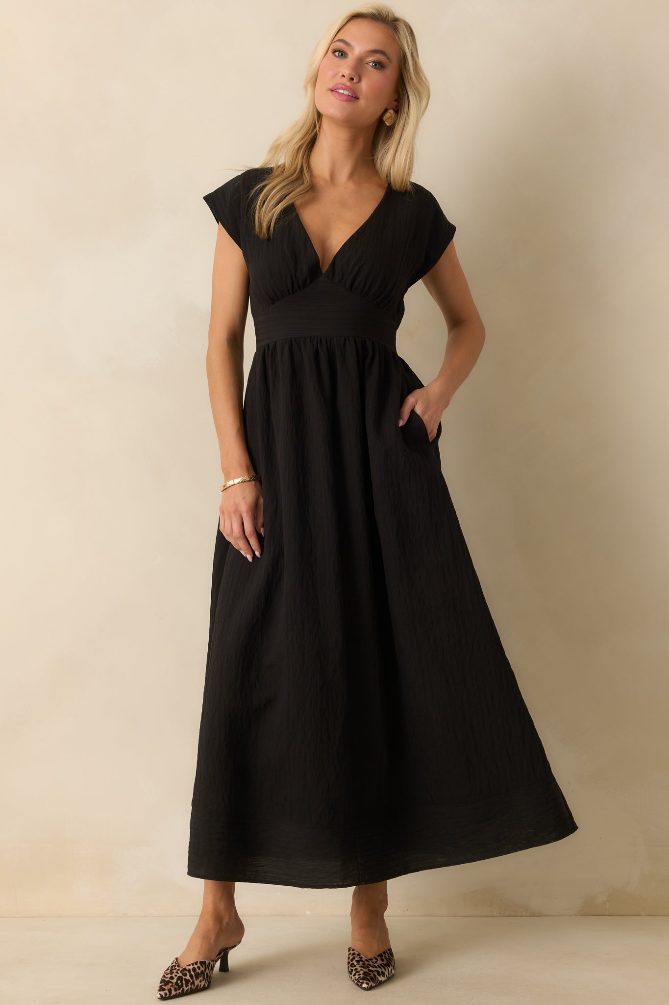 Black midi dress with a deep v-neckline and gathered bust detail.