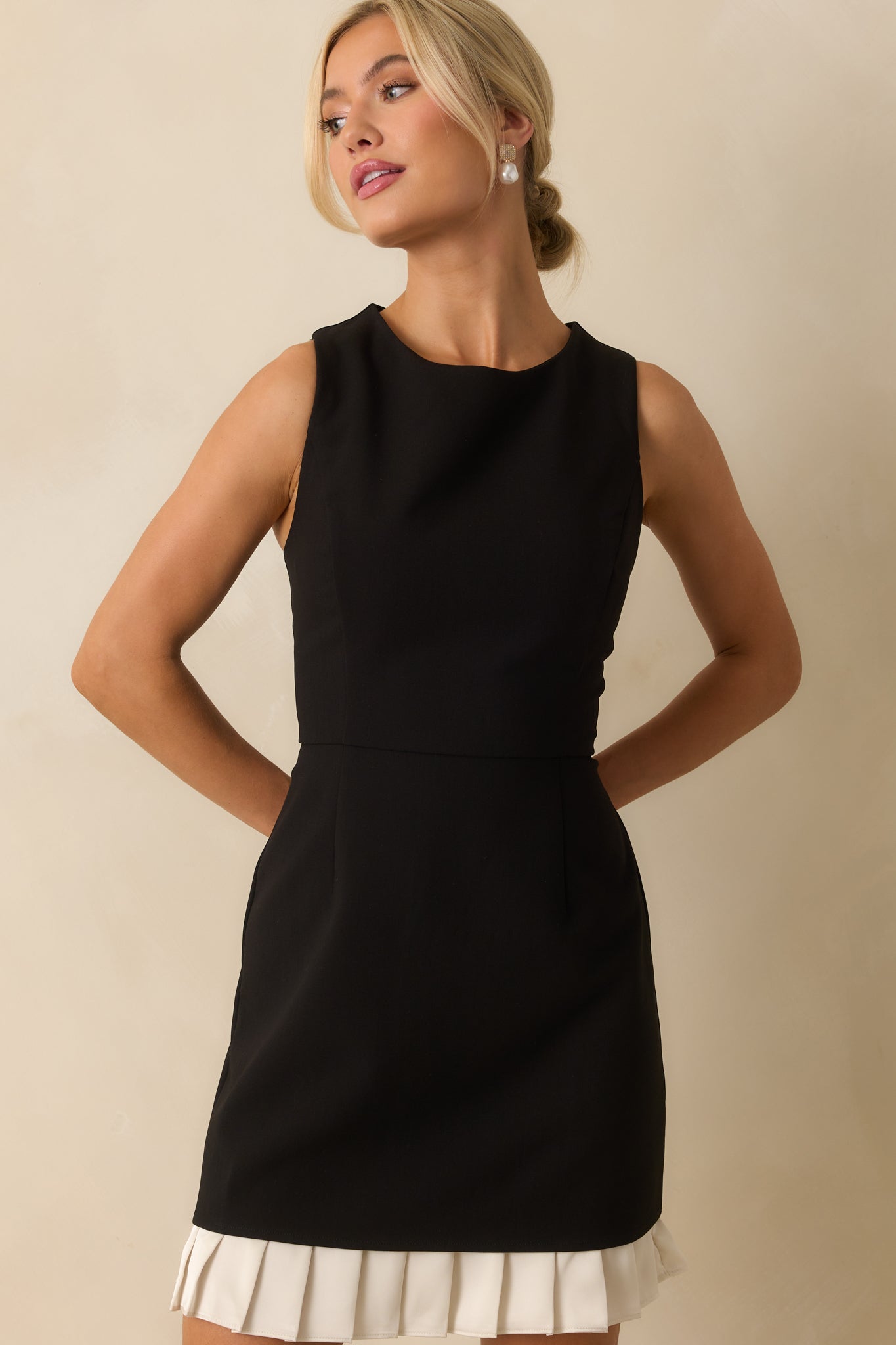 Detailed look at the sleek front and subtle shaping of the black mini dress.
