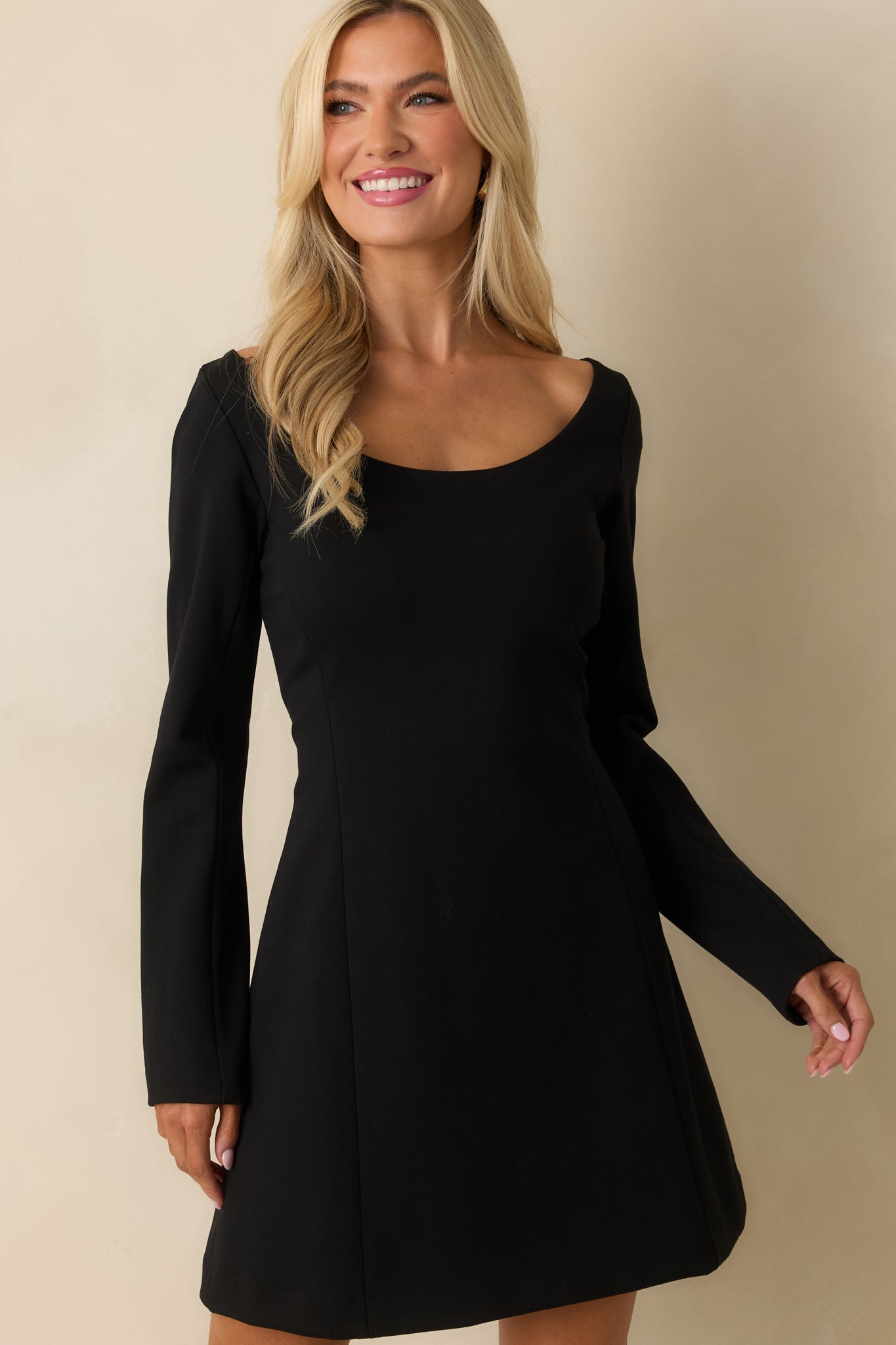 Black mini dress fabric detail with form-fitting cut and soft, stretchy long sleeves.