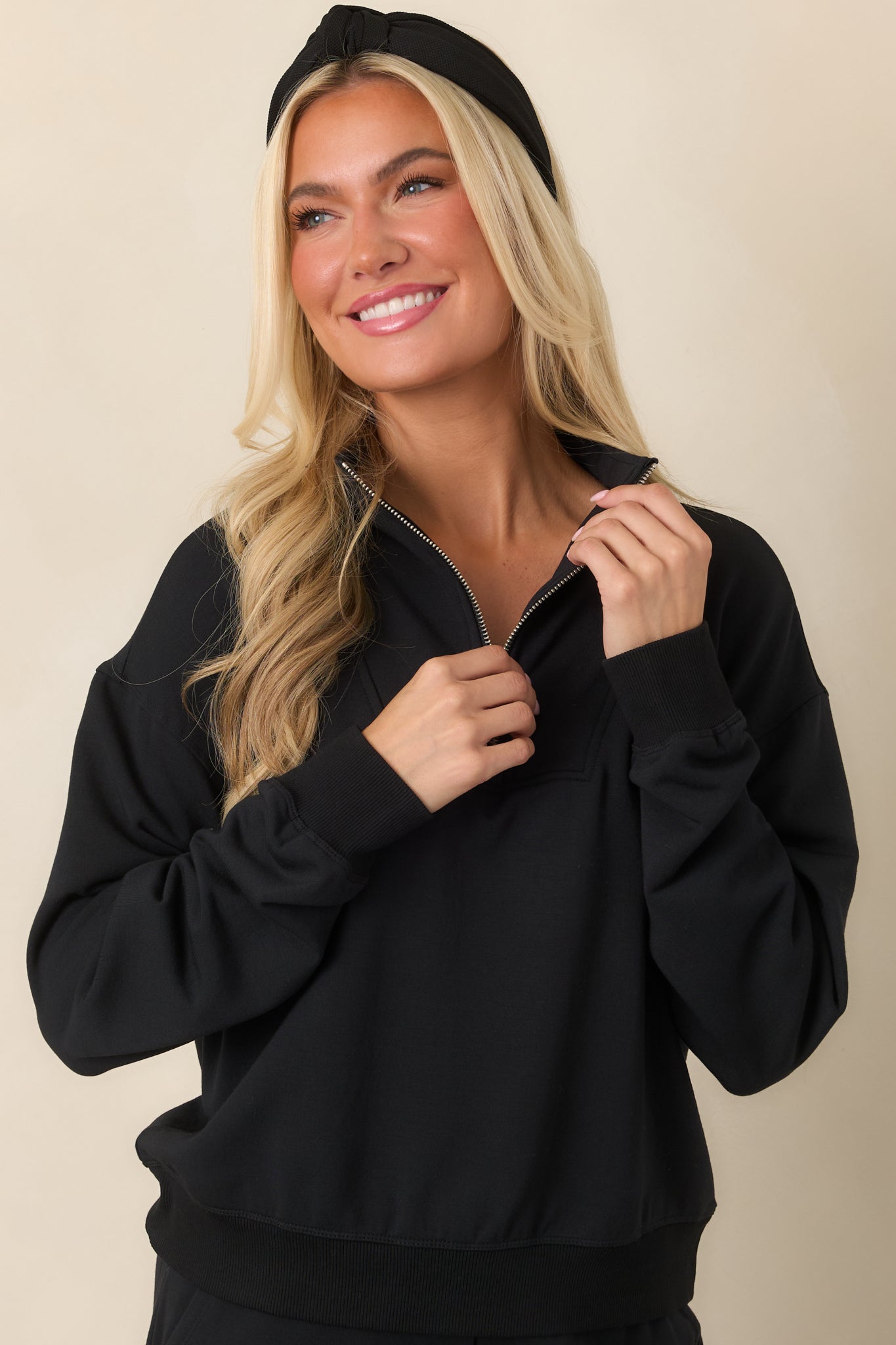 Close view of the black sweatshirt's stand collar and half-zip neckline, finished with a smooth modal-blend fabric.