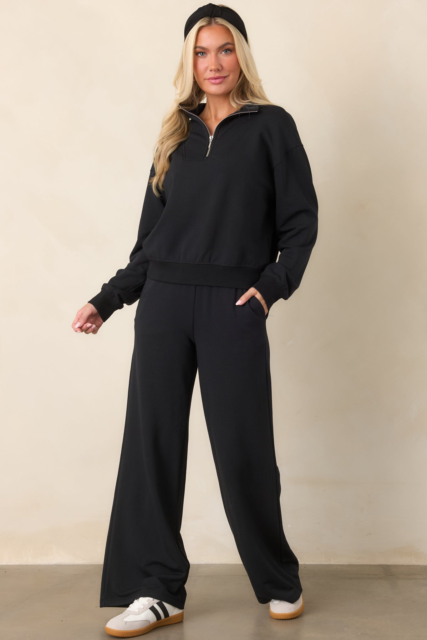 Classic black modal-stretch pants with an elastic waistband, relaxed wide-leg silhouette, smooth fluid drape, and practical side pockets.