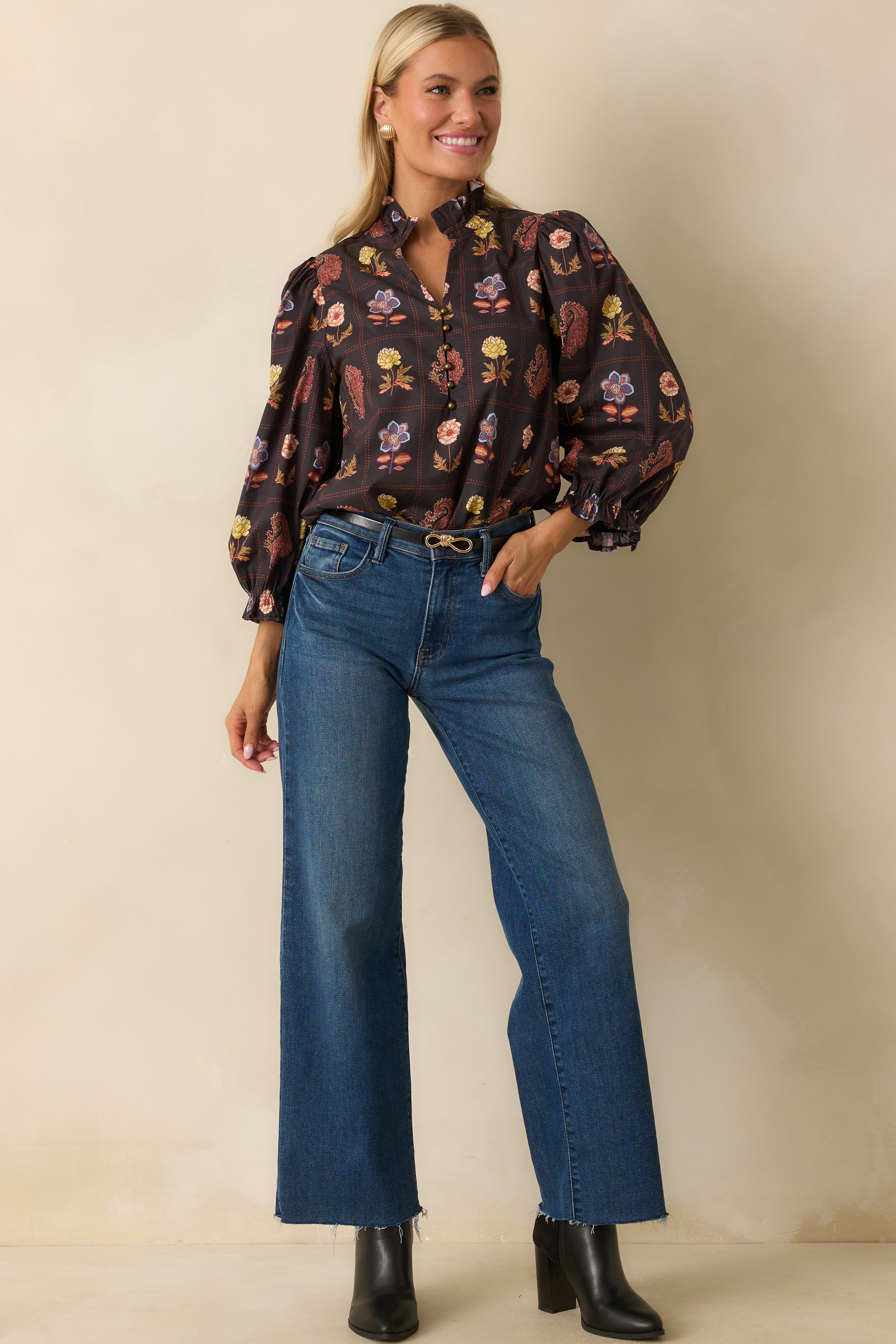 Black multi floral blouse with half-button front, ruffled neckline, and long puff sleeves in a relaxed fit