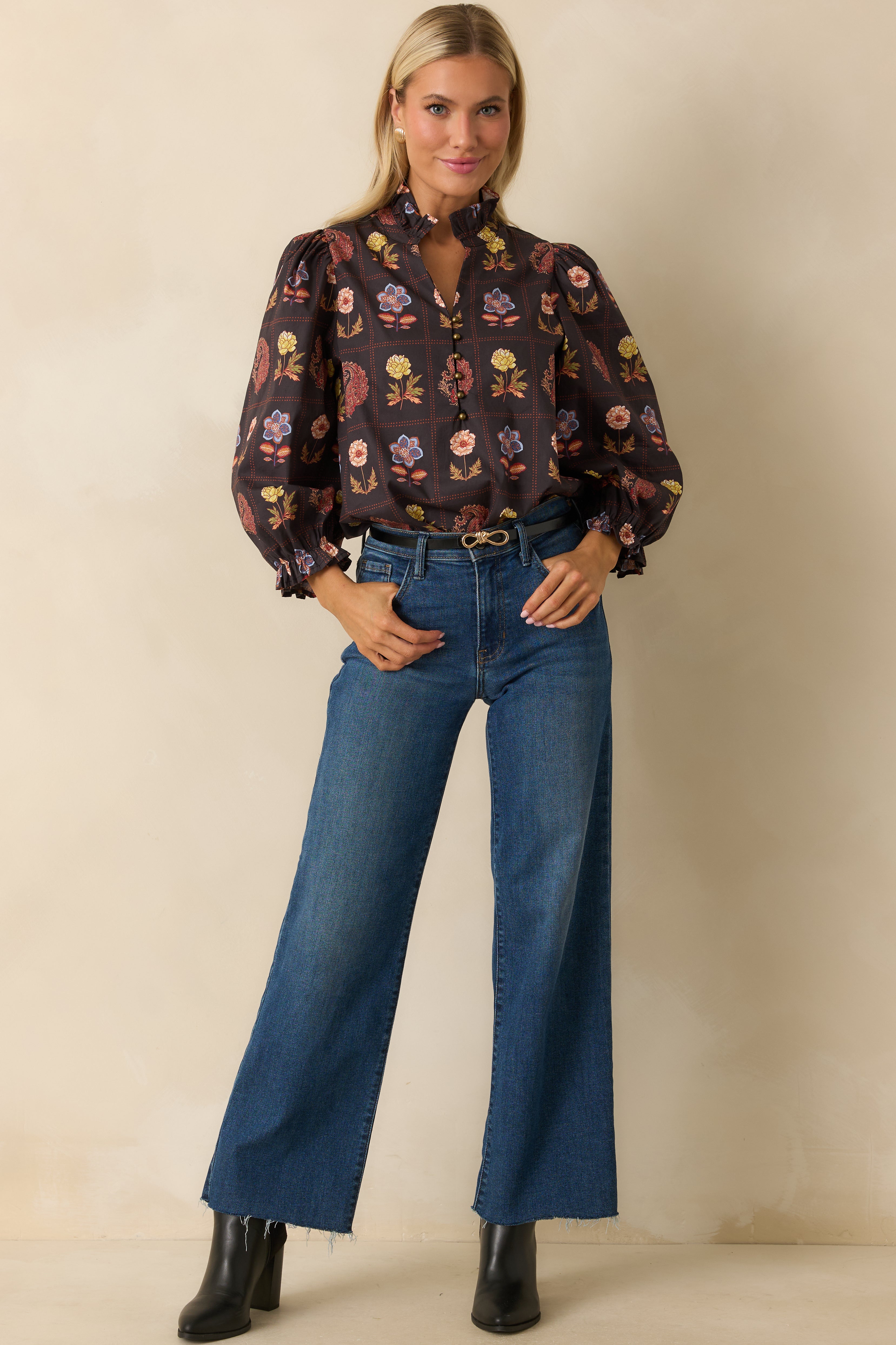 Black multi floral blouse with ruffled neckline, half-button front, and long puff sleeves