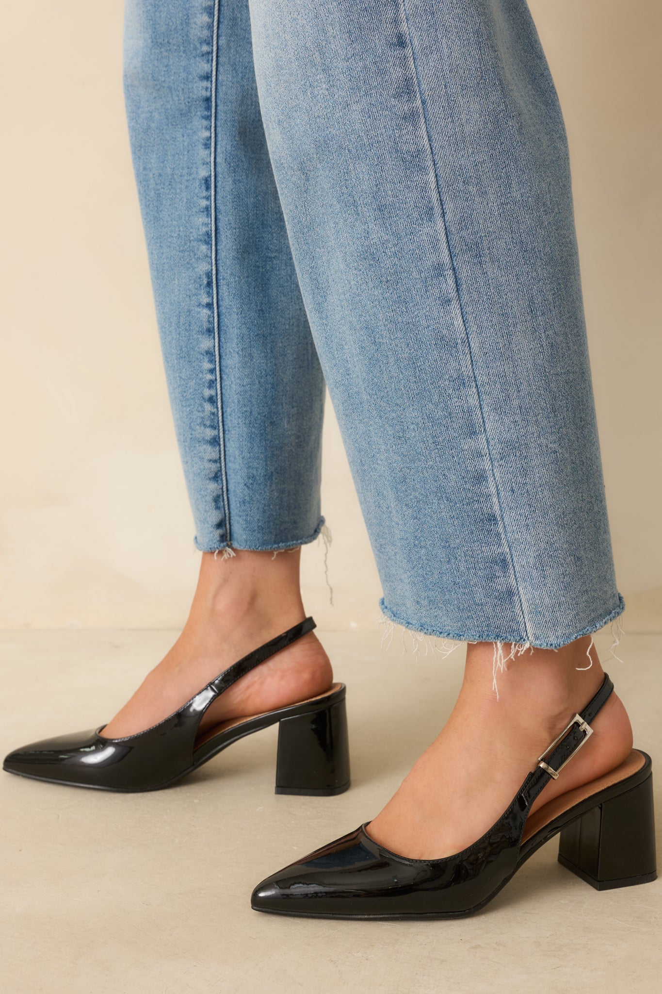 Black patent heels shown with a sleek pointed toe and glossy finish for a polished look