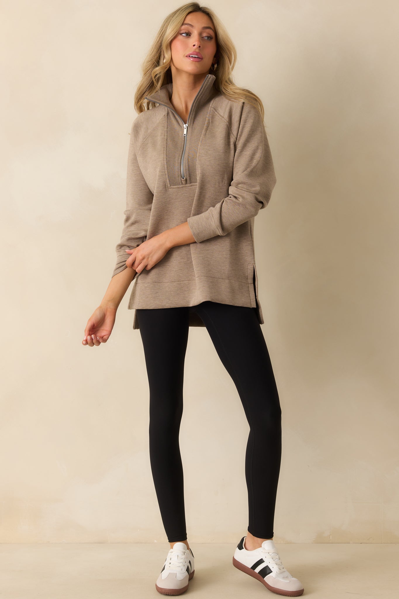 Model poses in black performance leggings designed for comfort and gentle mid-tummy shaping.