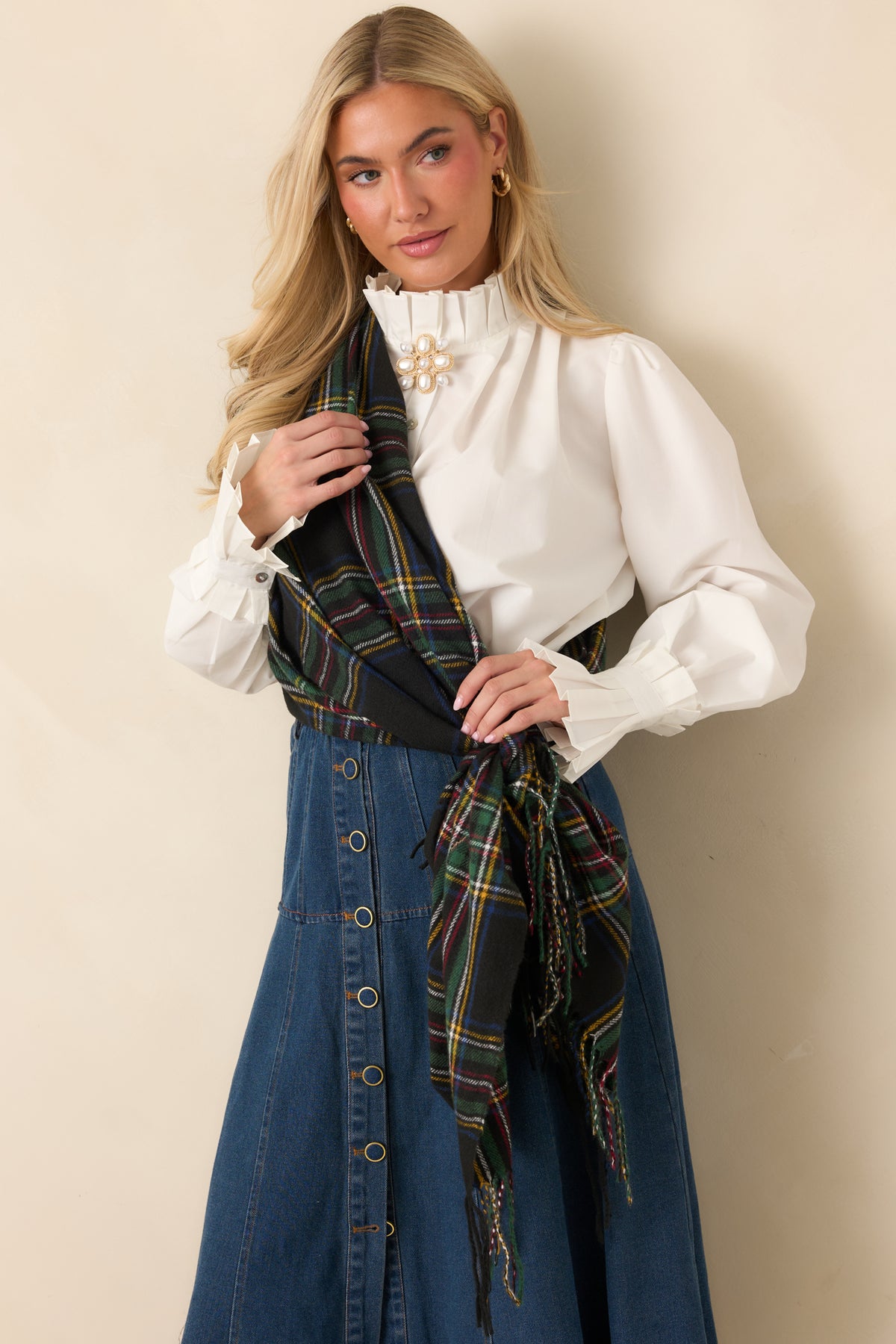 Black plaid scarf with forest green, burgundy, mustard gold, ivory, and blue tartan stripes and twisted fringe.