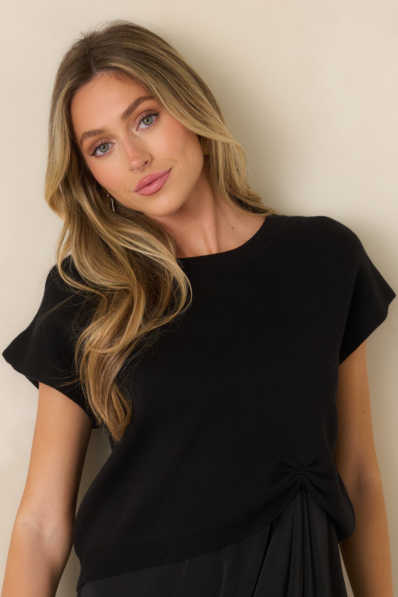 Close view of the black cotton-blend sweater showcasing the ribbed neckline and softly textured knit construction.