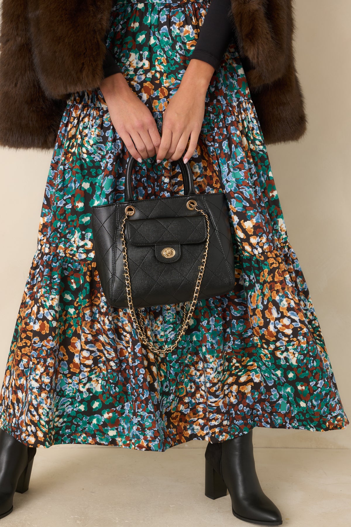 Roomy black handbag featuring a slim flap, magnetic snap closure, and structured top handles.