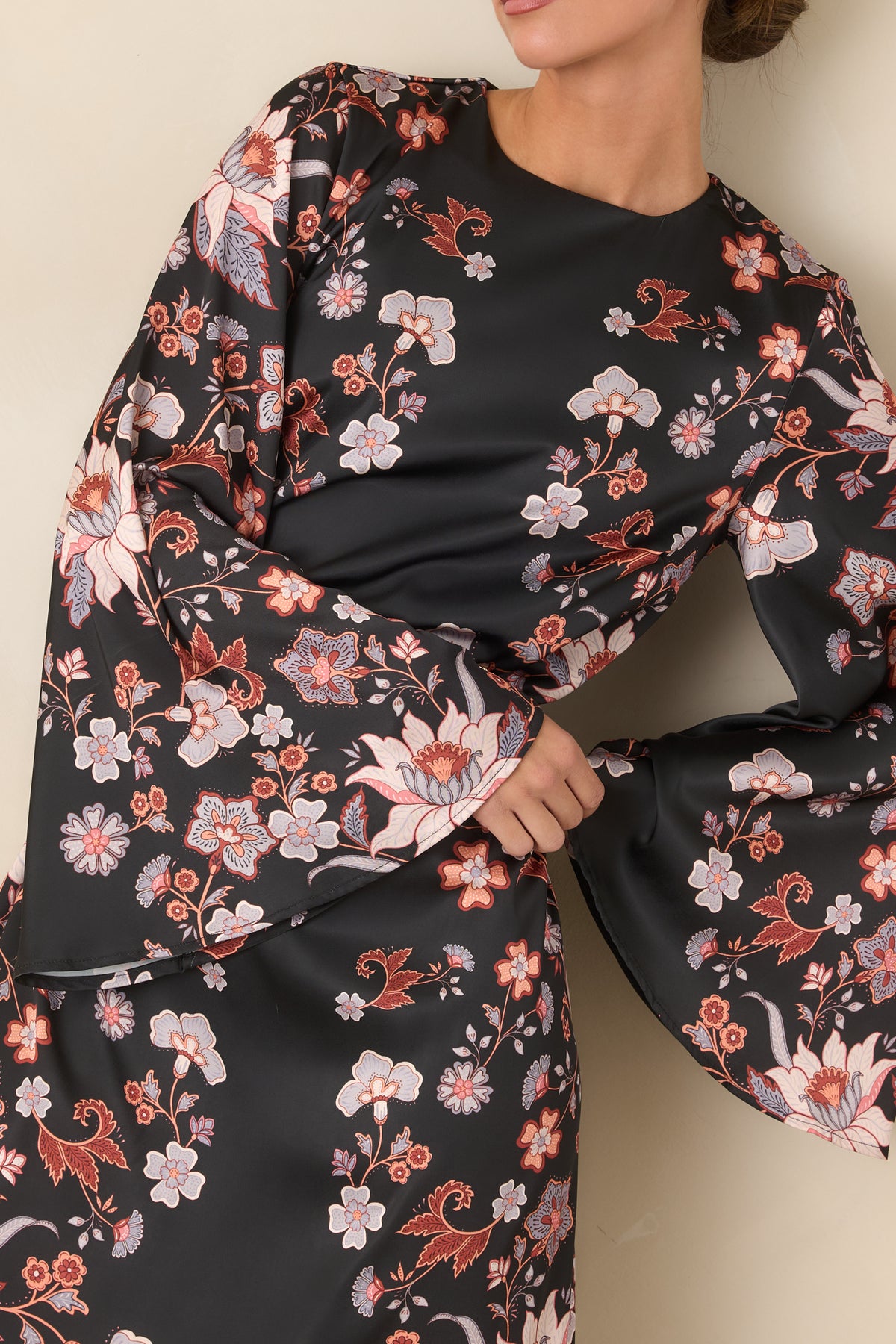 Black satin dress detail highlighting the blush pink, ivory, rust, and muted blue trailing blooms.