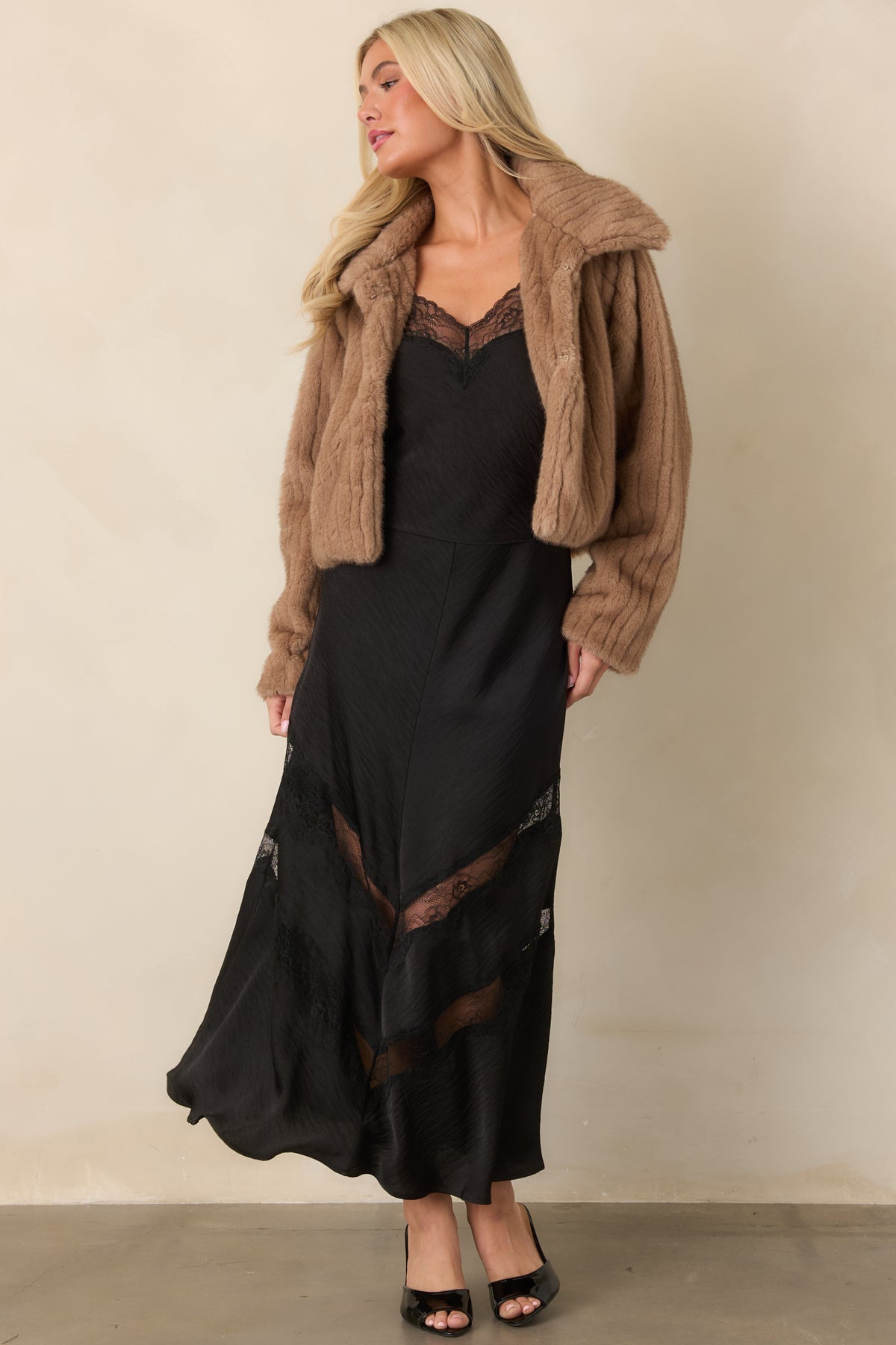 Polished black satin top showcasing a fluid cropped silhouette, adjustable straps, and lace-trimmed neckline.