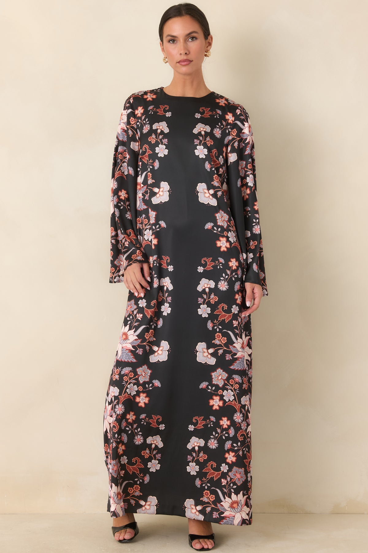 Black satin dress showcasing colorful trailing blooms and voluminous wide sleeves.