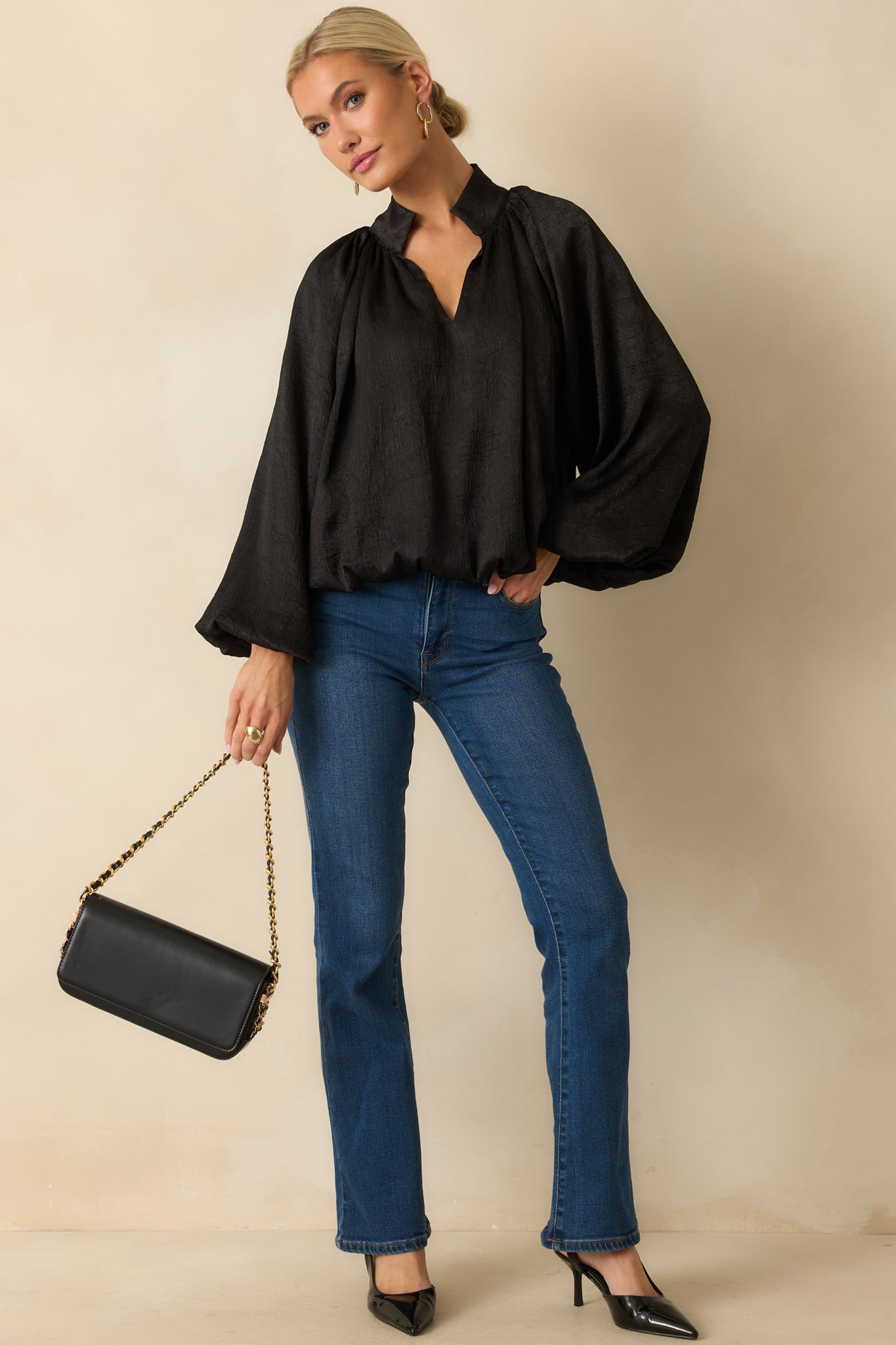Black satin V-neck top with long peasant sleeves, gathered cuffs, and a relaxed, subtly textured silhouette.