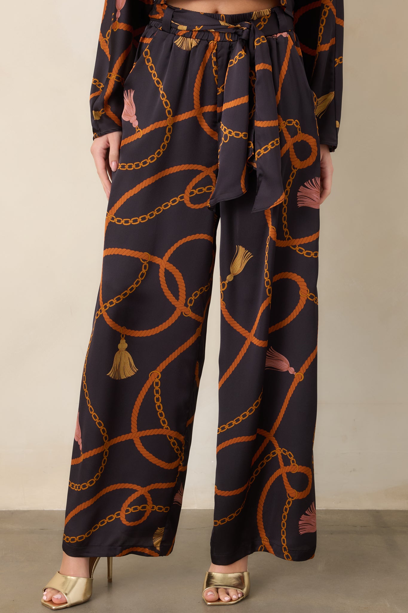 Wide-leg pants showcasing the silky satin-feel texture and colorful rope, chain, and tassel motifs.