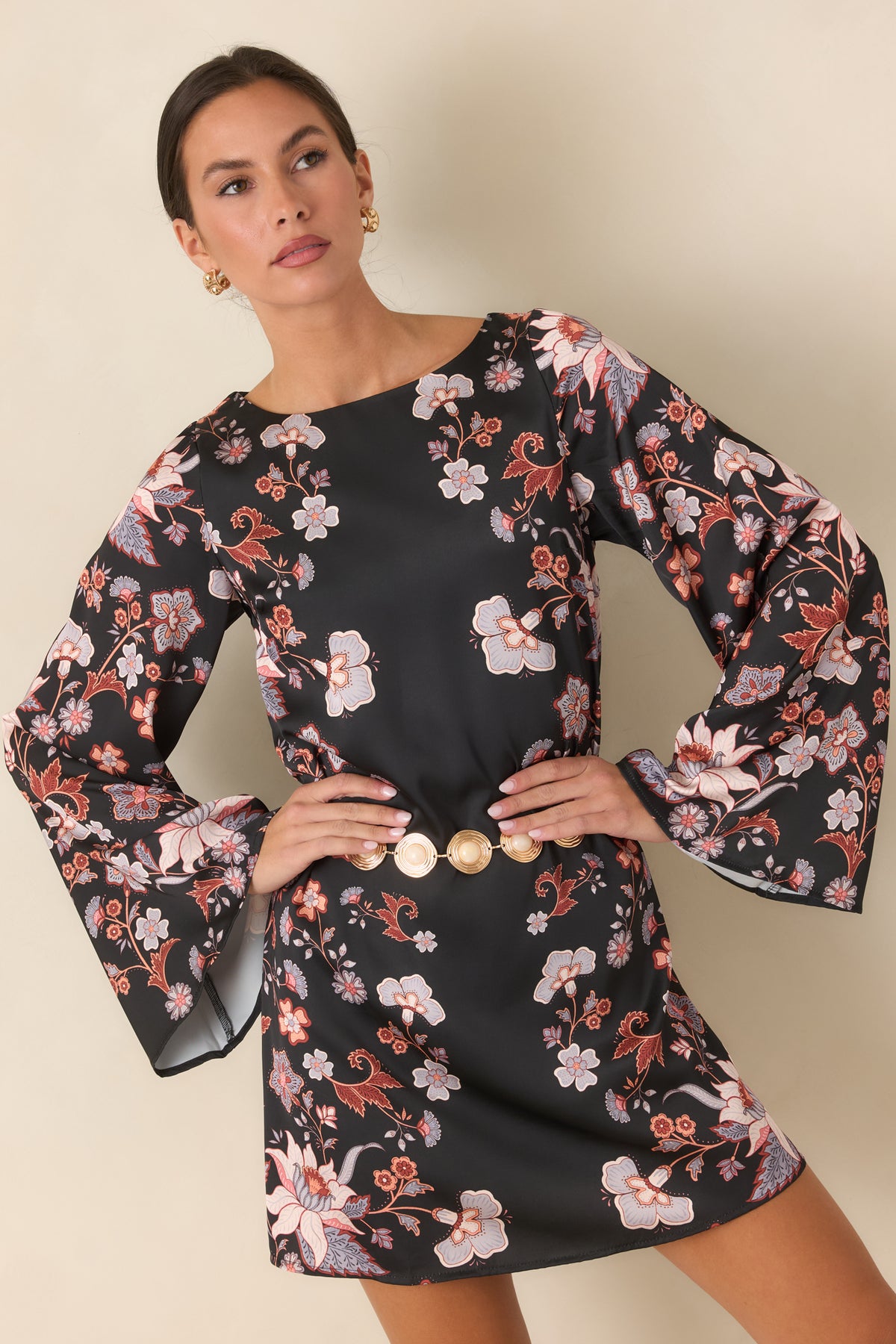 Black satin dress highlighting the wide round neckline and periwinkle floral blooms across the fabric.
