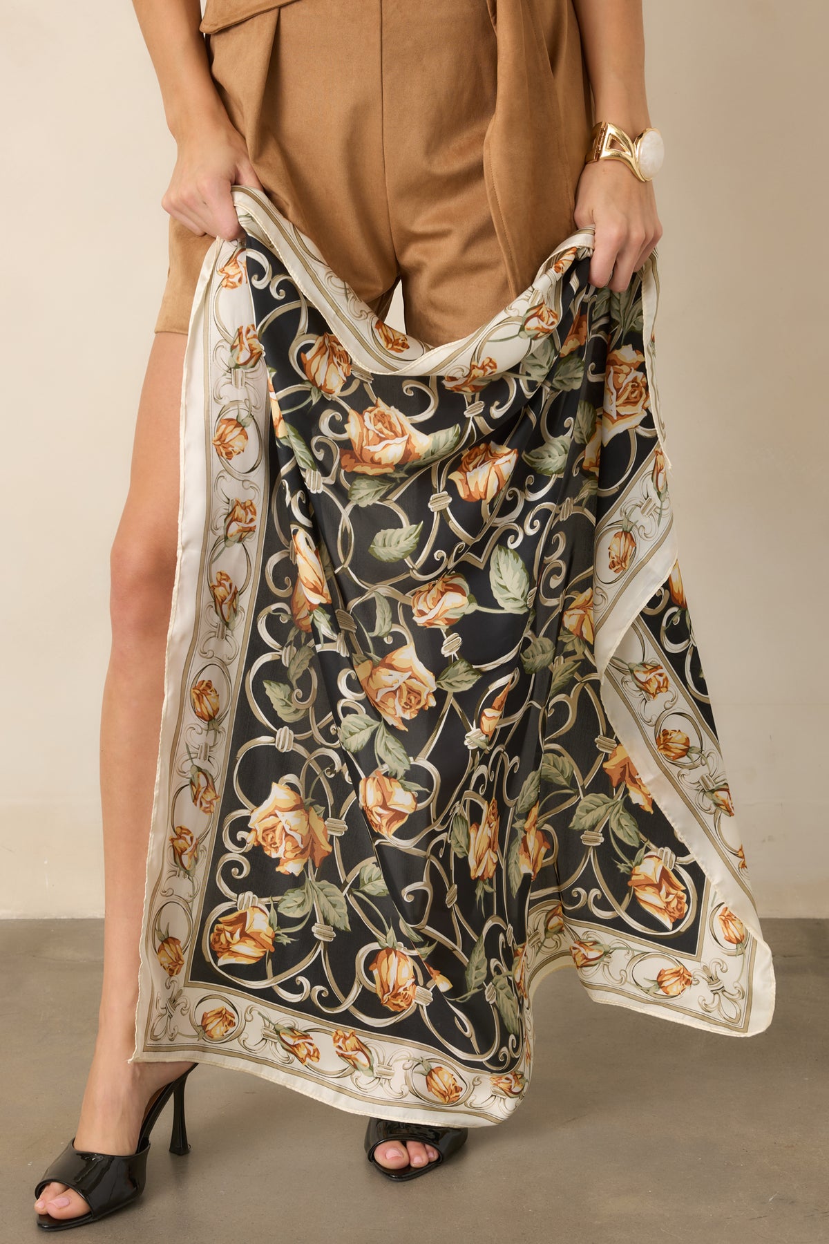 Striking black scarf showcases pastel orange roses, winding vines, and an ivory border with decorative floral detailing.
