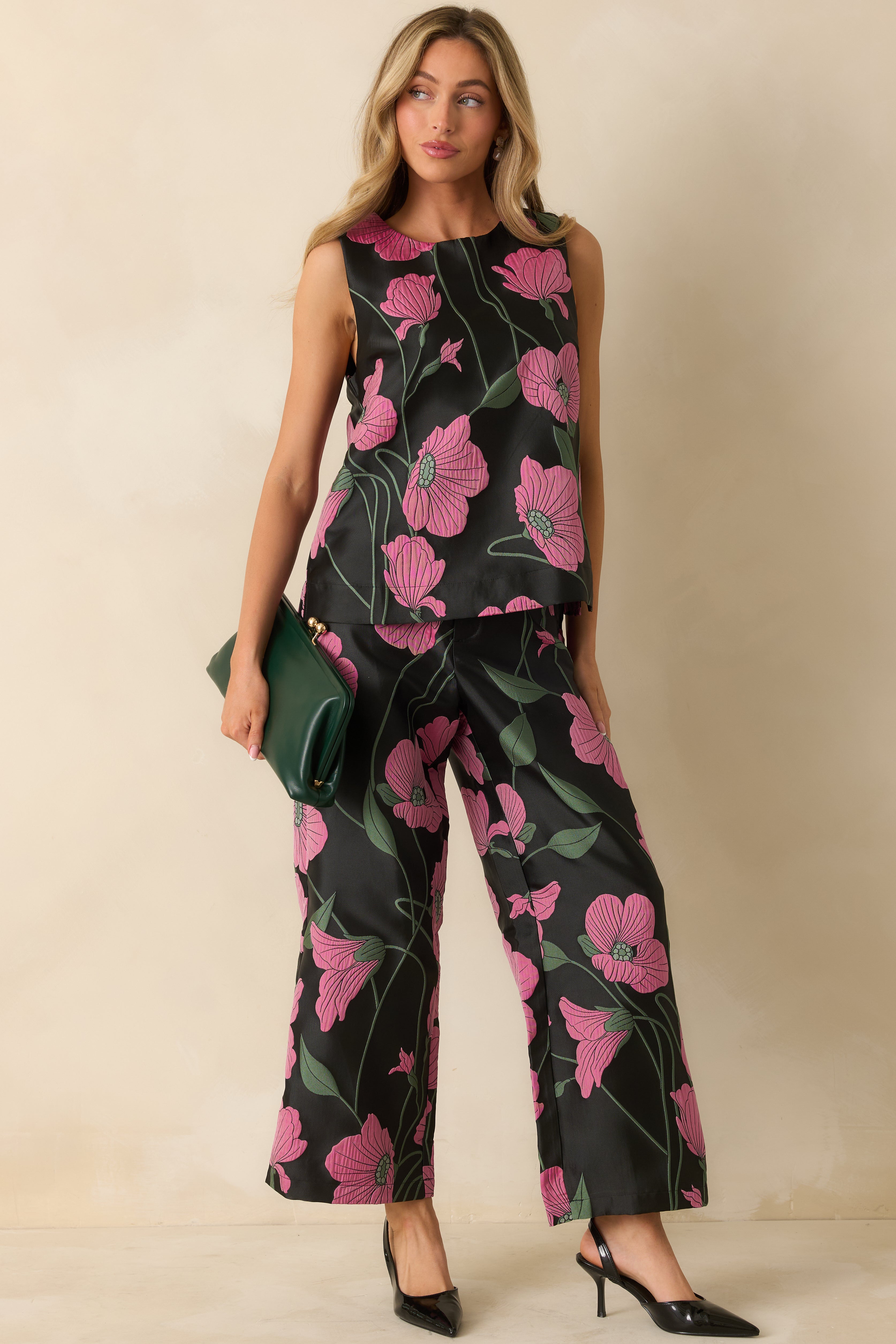 Black sleeveless jacquard top with tailored seaming and vibrant pink and green floral pattern, styled for a sleek, structured look.