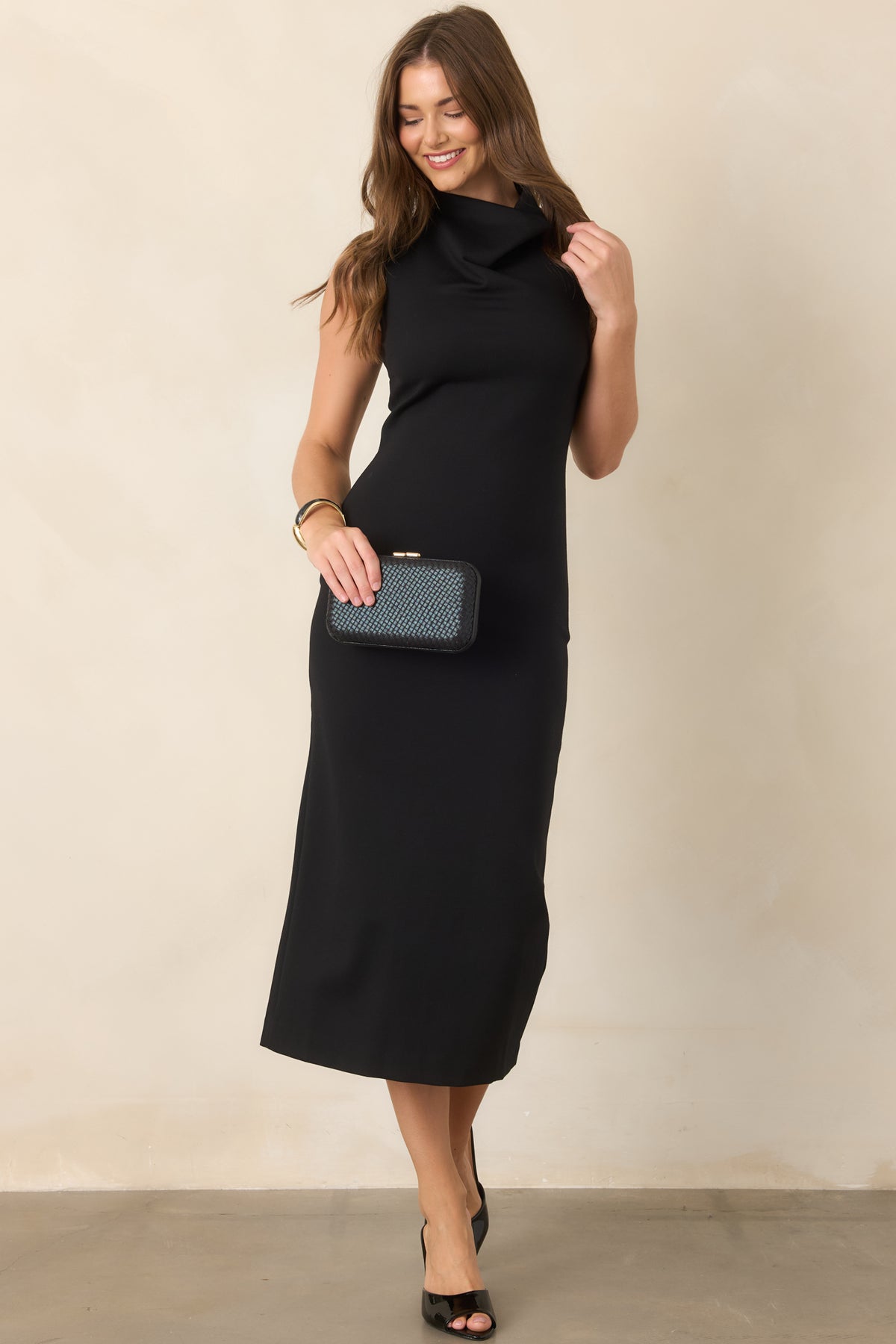 Black sleeveless ponte dress highlighting its close-fitting midi silhouette and elegant high neckline.
