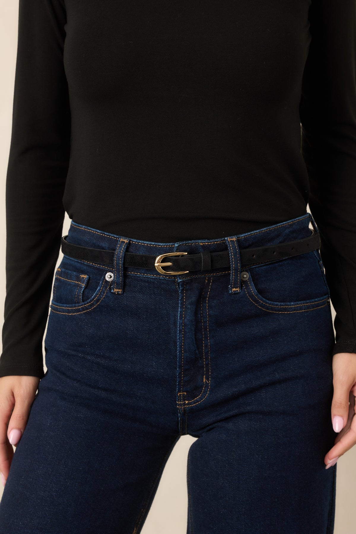 Slim black belt with a smooth finish and polished gold oval buckle.