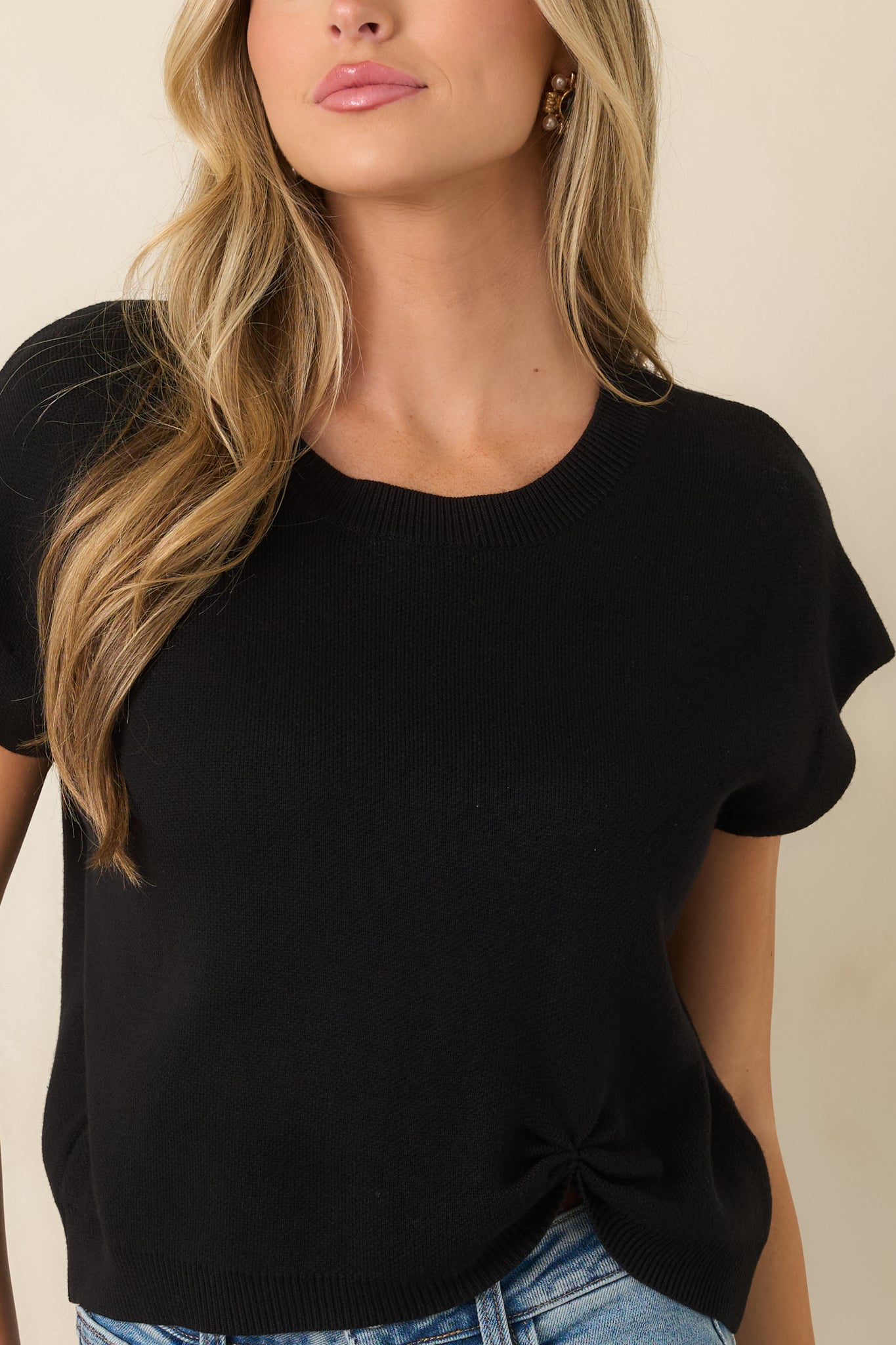 Soft black sweater with a relaxed drape, emphasizing the cotton-acrylic knit and subtle shaping at the hem.