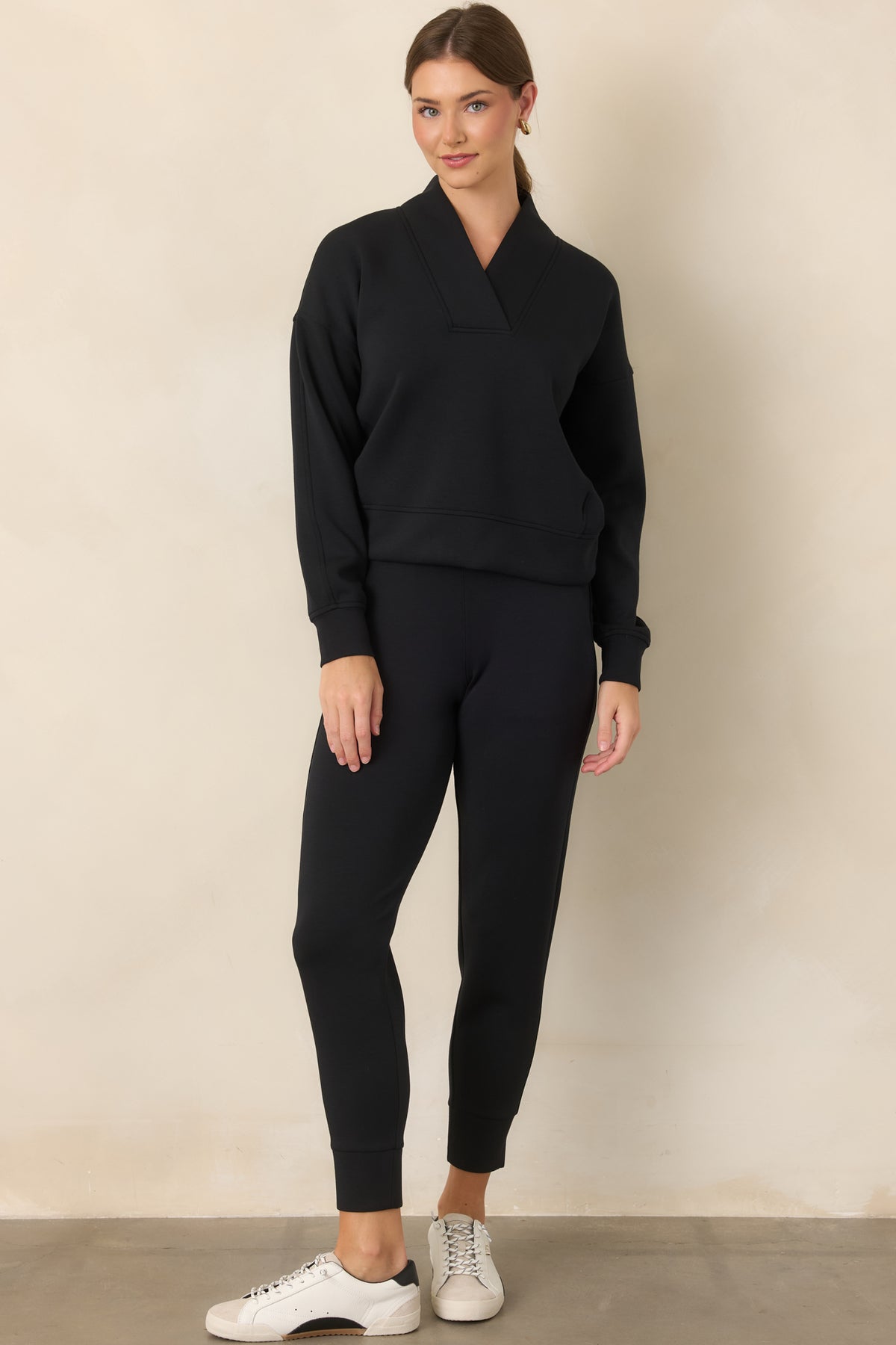 Smooth black spacer pants showcasing four-way stretch, a streamlined tapered shape, side pockets, and banded hems