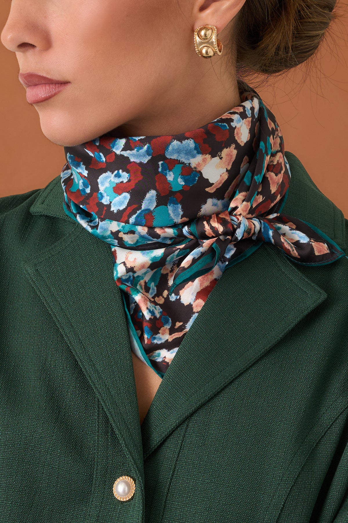 Square black scarf featuring an abstract animal print in teal, blue, rust, peach, and ivory.
