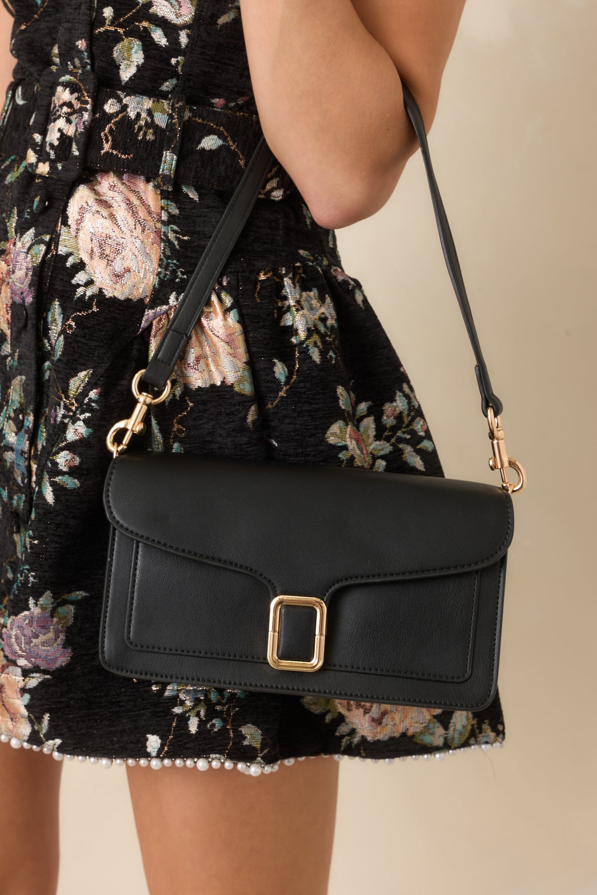 Structured black handbag showcasing tonal edge stitching and matching gold-tone strap clips.
