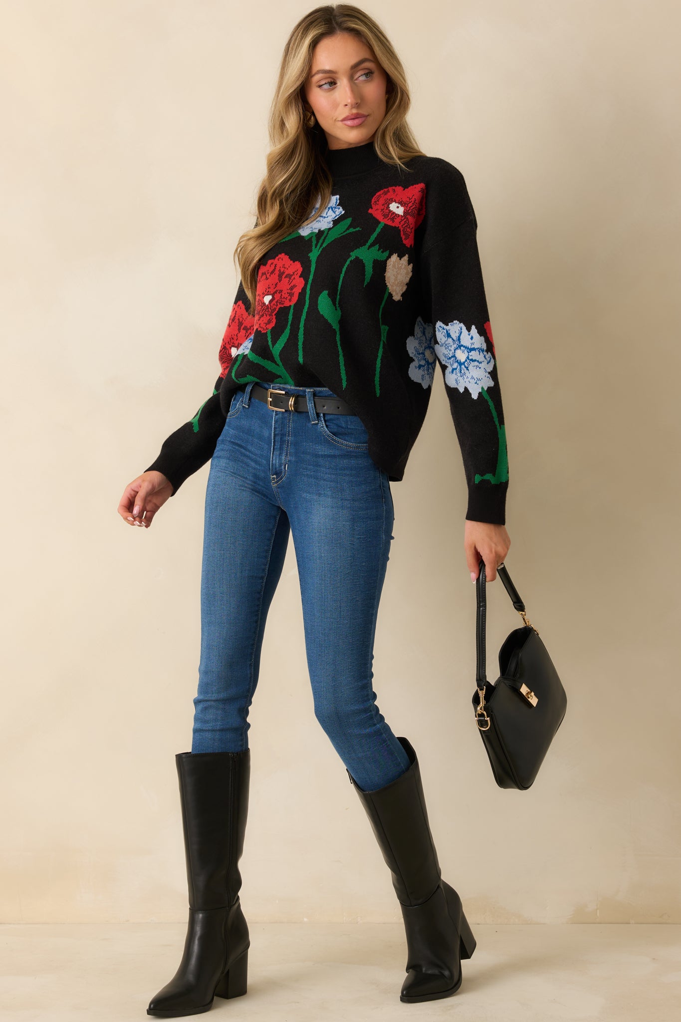 Relaxed-fit black sweater with long sleeves, ribbed trim, and an intricate multicolor floral jacquard design.