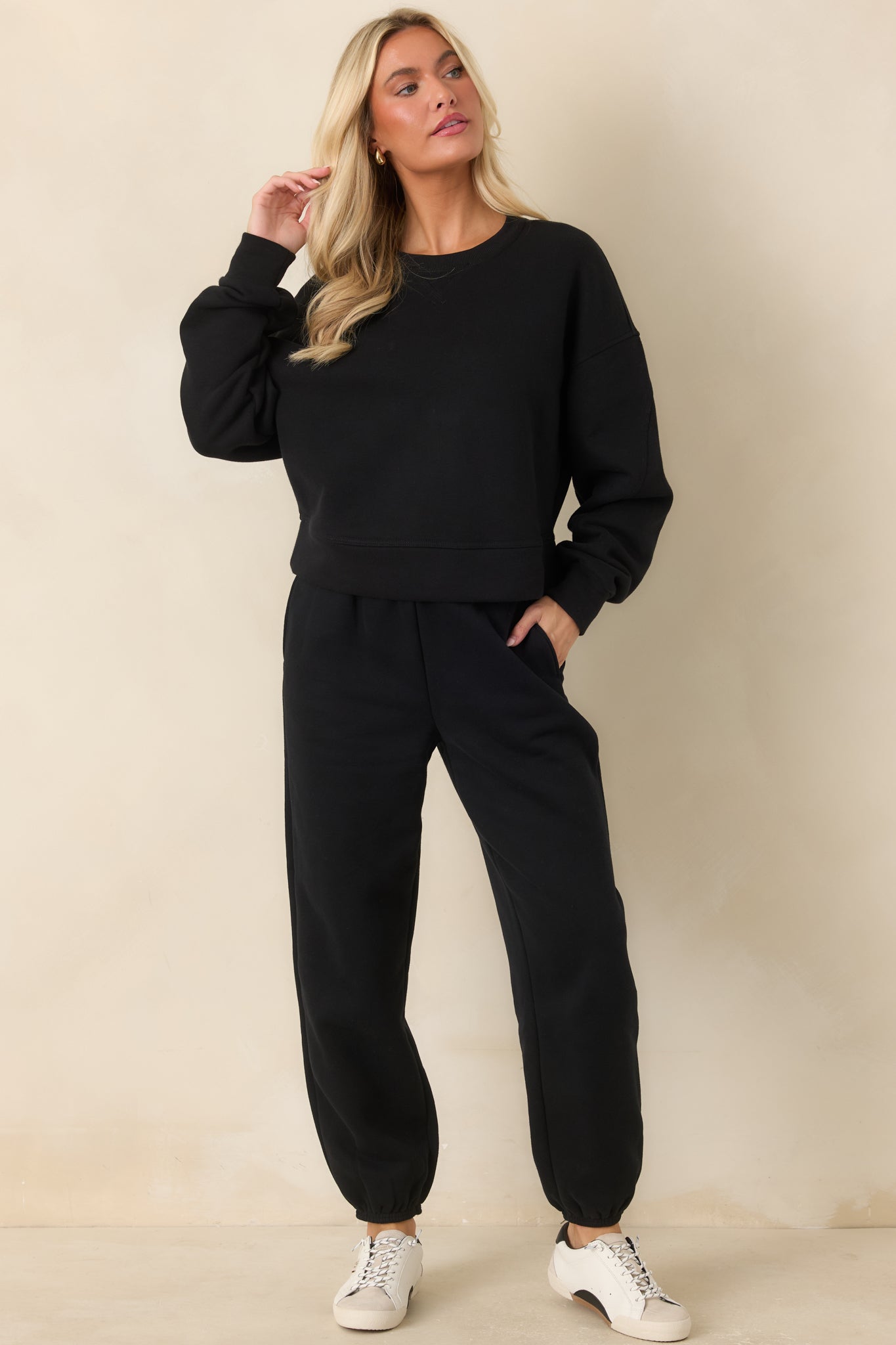Black sweatshirt showcasing curved sleeve seaming, a stitched V-inset neckline, ribbed trim, and a relaxed fit.