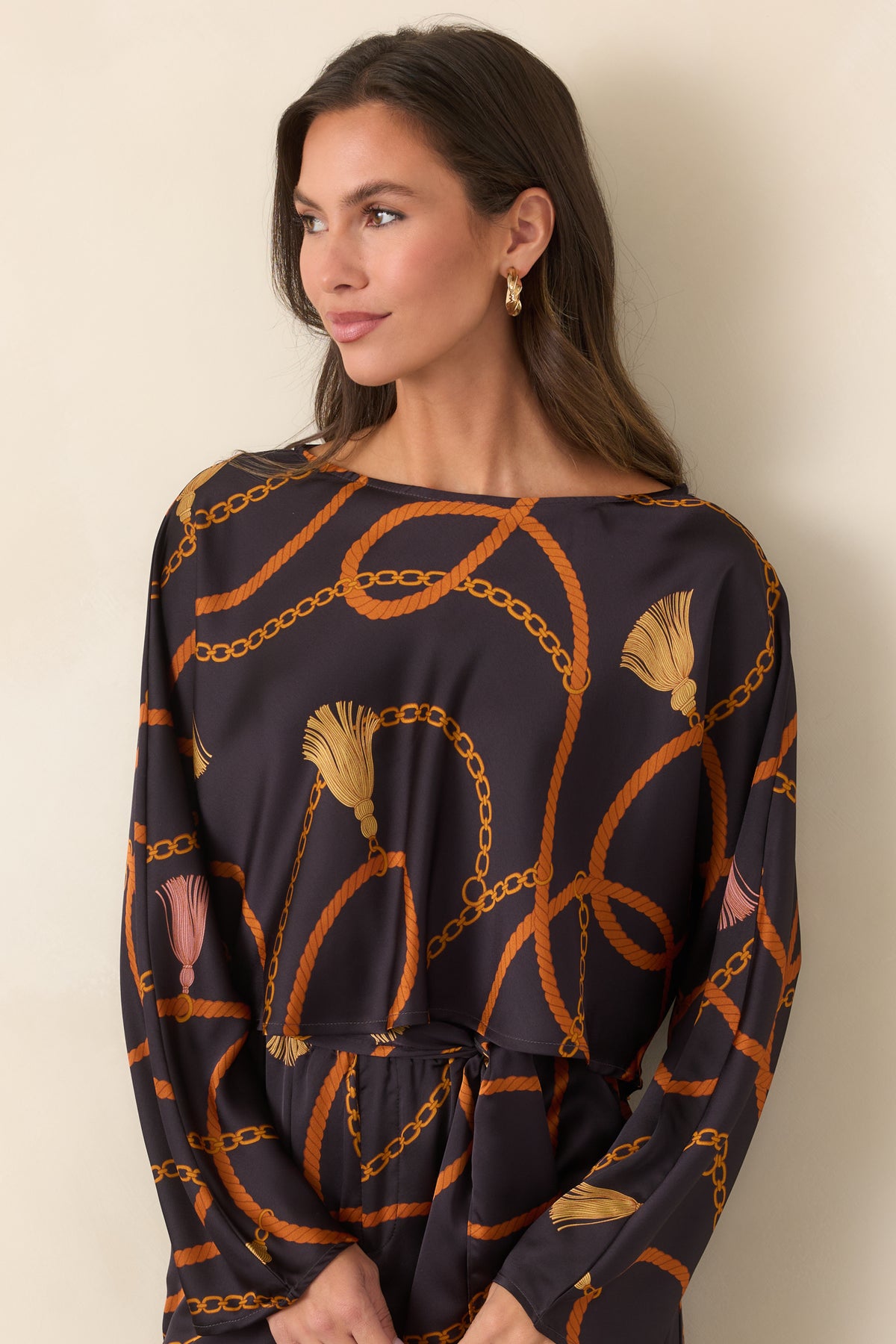 Black top highlighting the round neckline and ornate golden chain and rust rope print across the upper front.