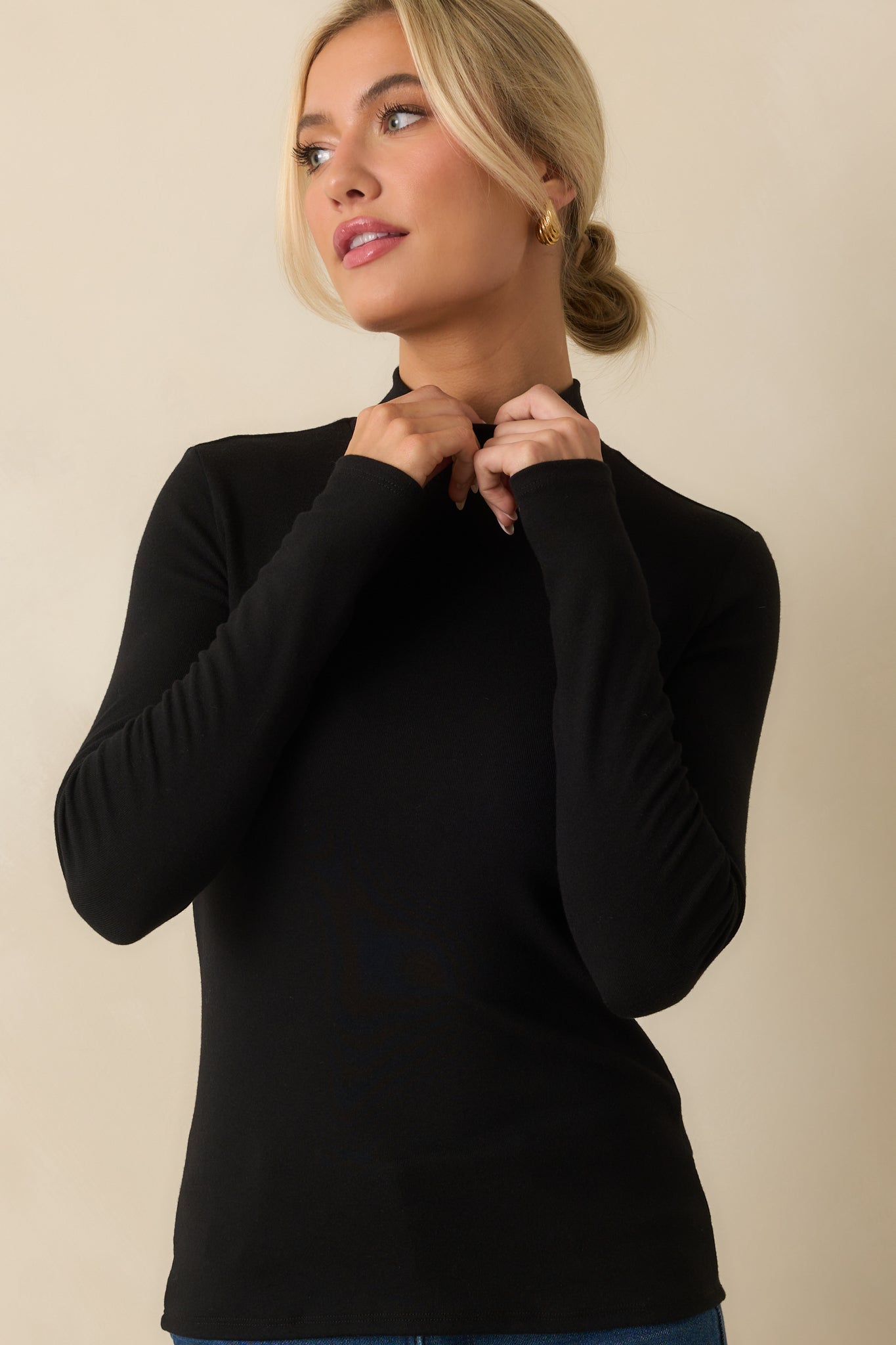 Close view of the fitted silhouette on the black lightweight turtleneck.