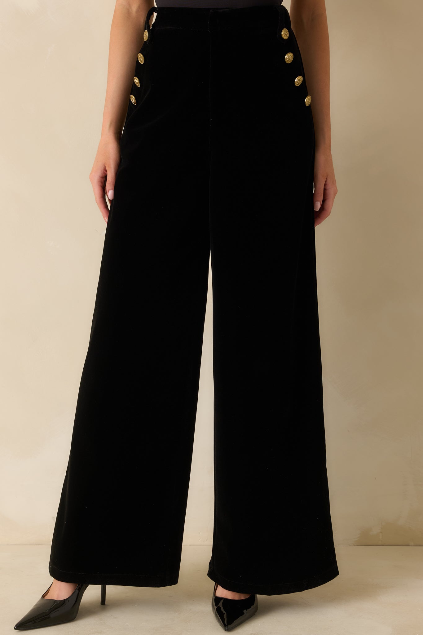 Detailed look at the side pockets and smooth structure of the black velvet pants.