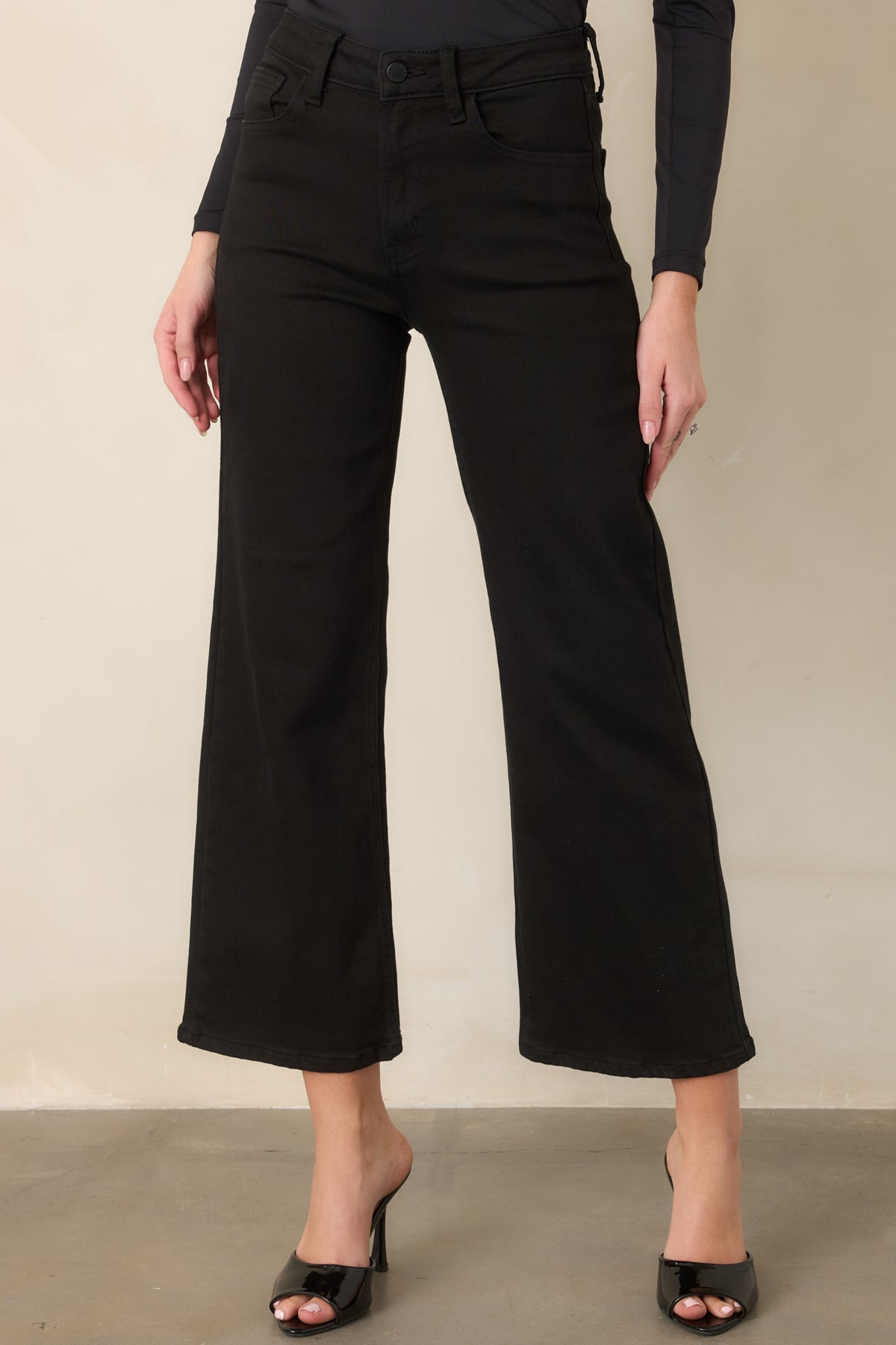 Black wide-leg jeans highlighting the high-rise waistband, belt loops, and classic button-and-zipper closure.