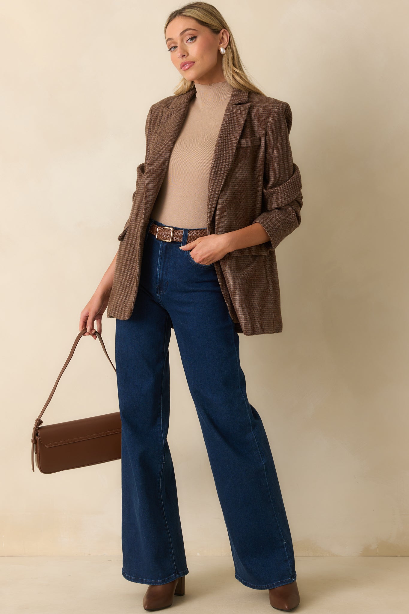 Front view of blazer featuring functional pockets, button cuffs, and structured longline fit.