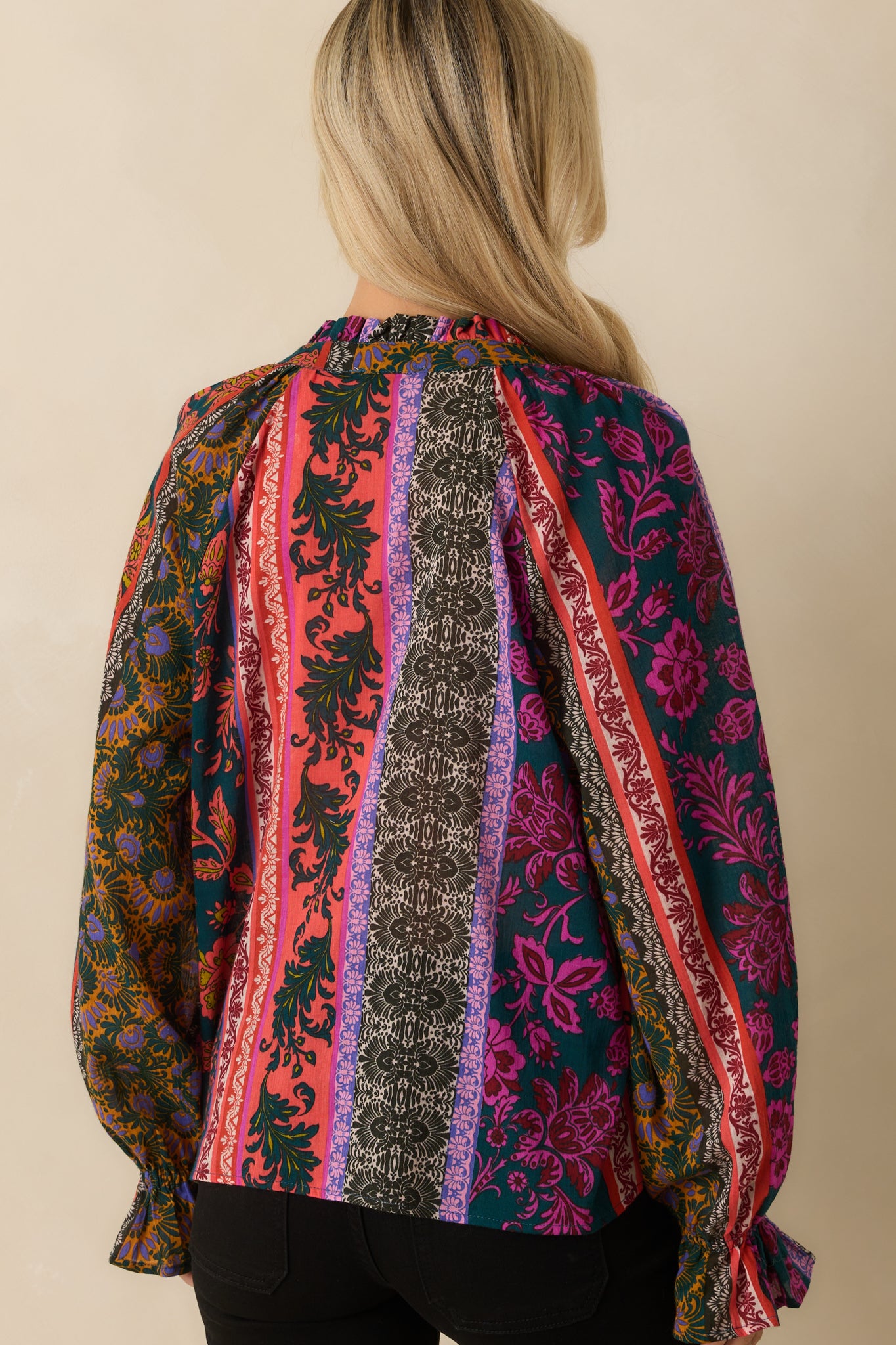 A back view of the blouse showing the allover patchwork print and ruffle trim along the shoulders.