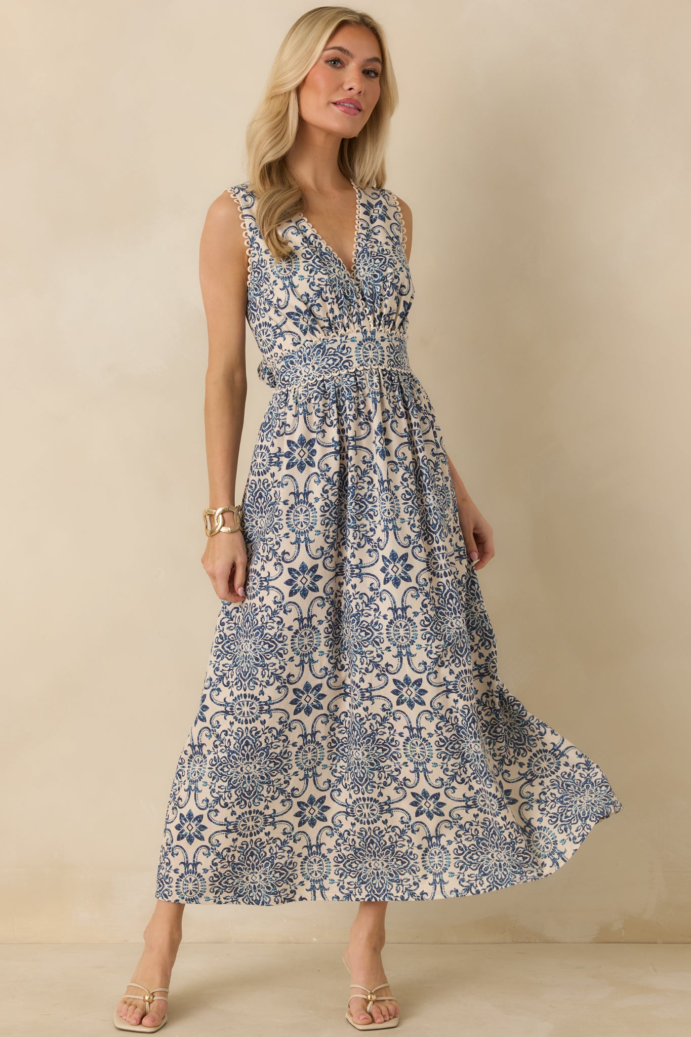 Blue and ivory tile-print midi dress with v-neckline, sleeveless bodice, and fitted waistband.